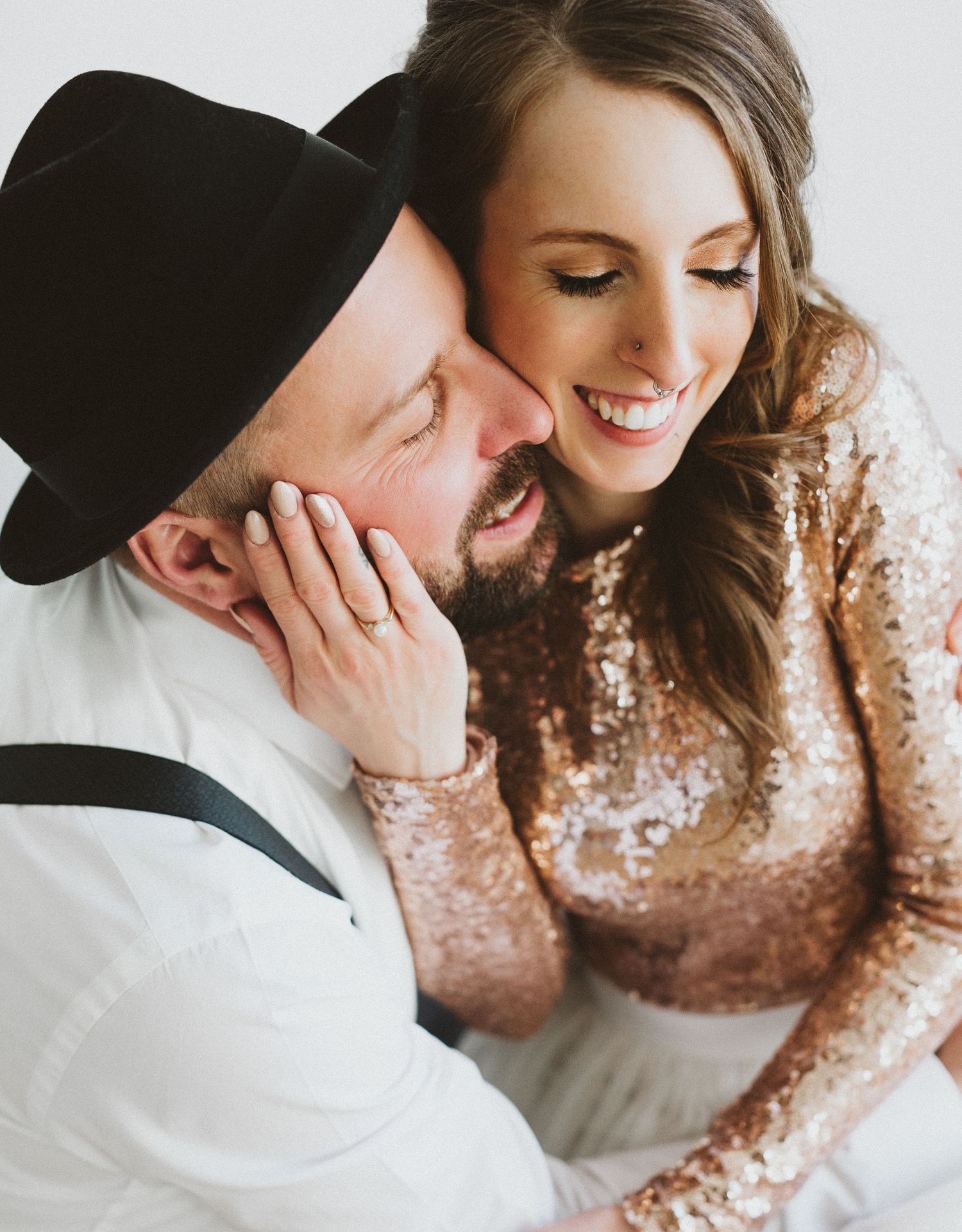 Intimate couple moment captured in rose gold sequined dress detail.
