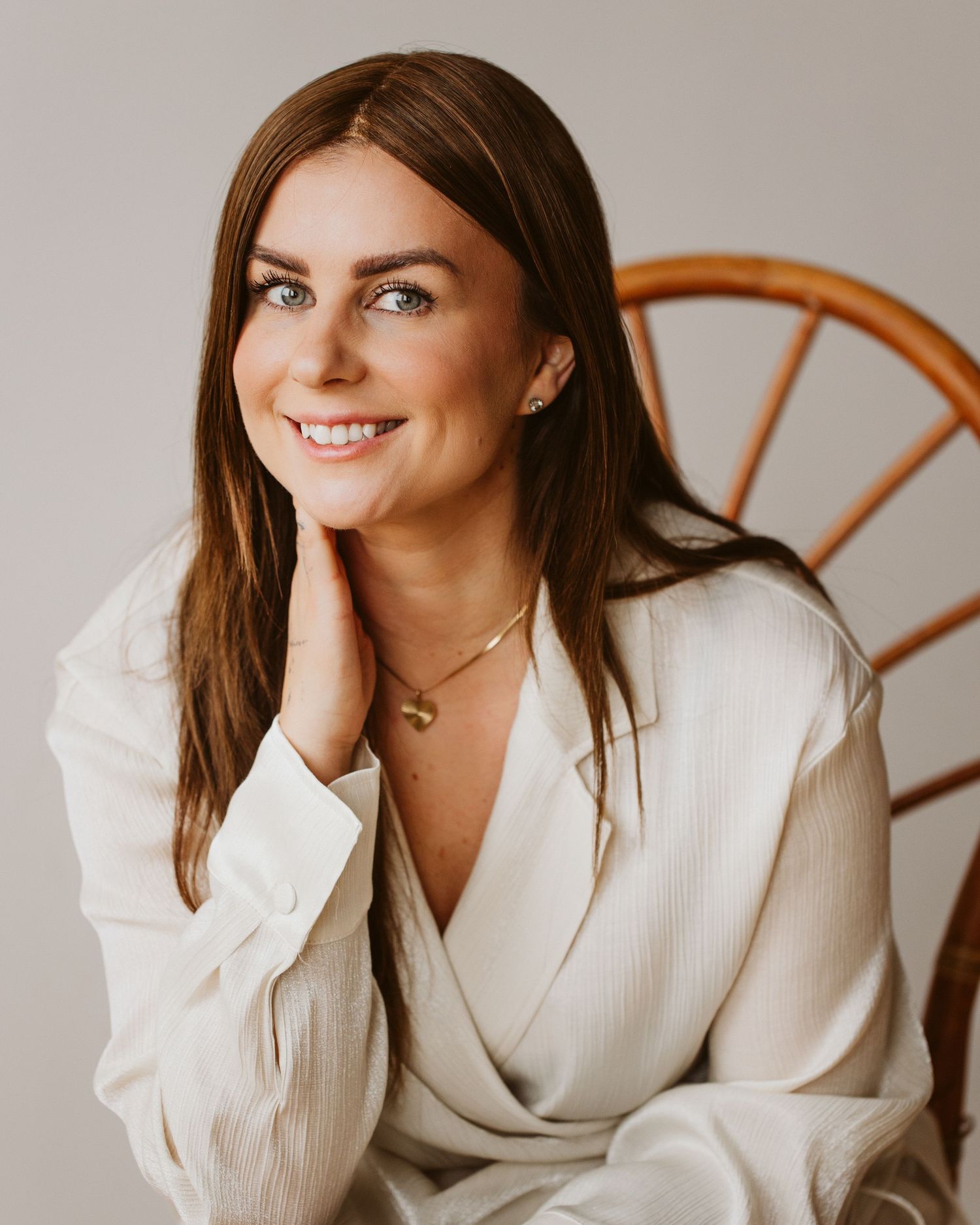 Elegant portrait session with cream colored blazer against neutral backdrop.