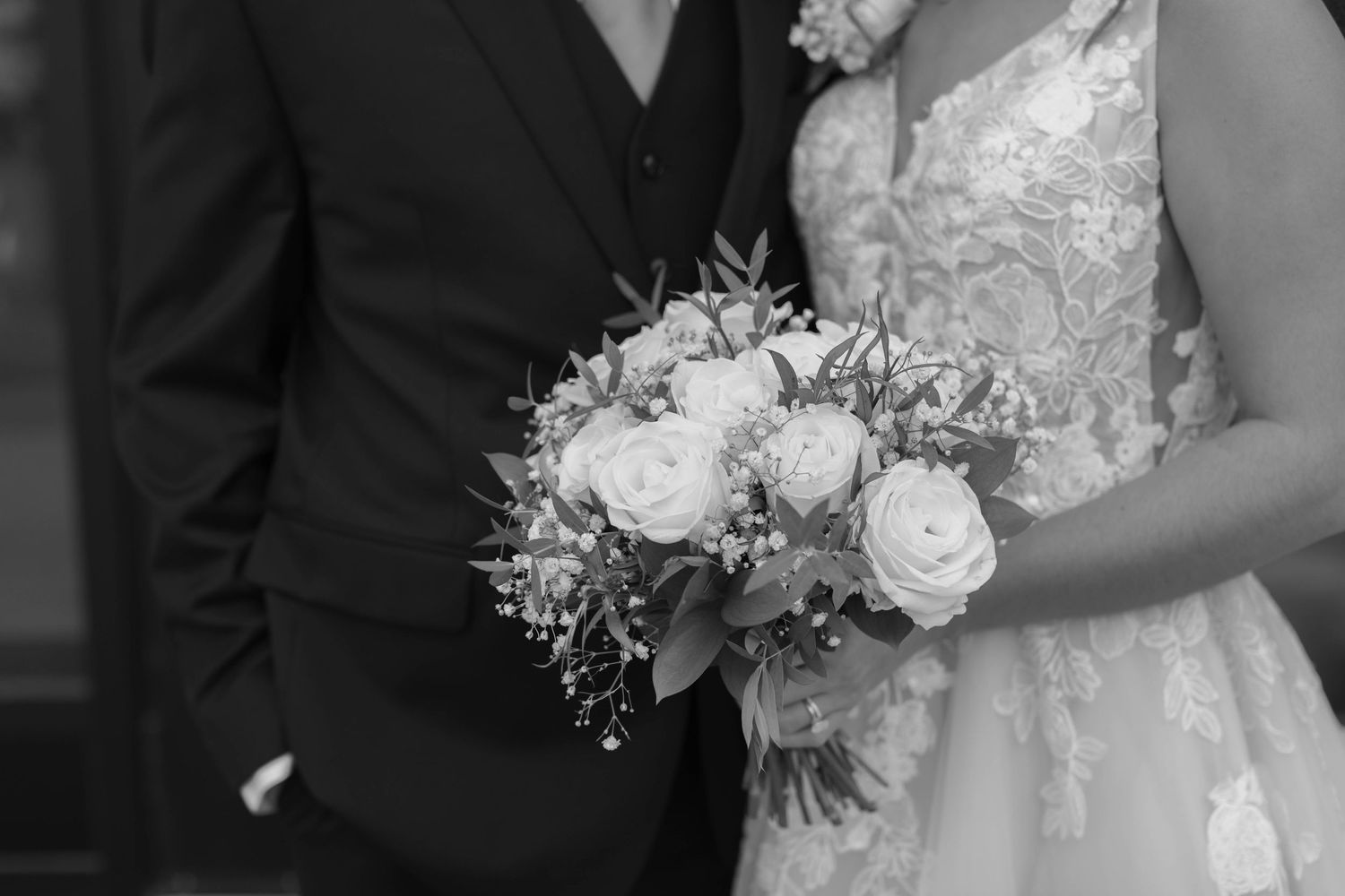 Detail photo of bride and groom with bridal bouquet in black and white.