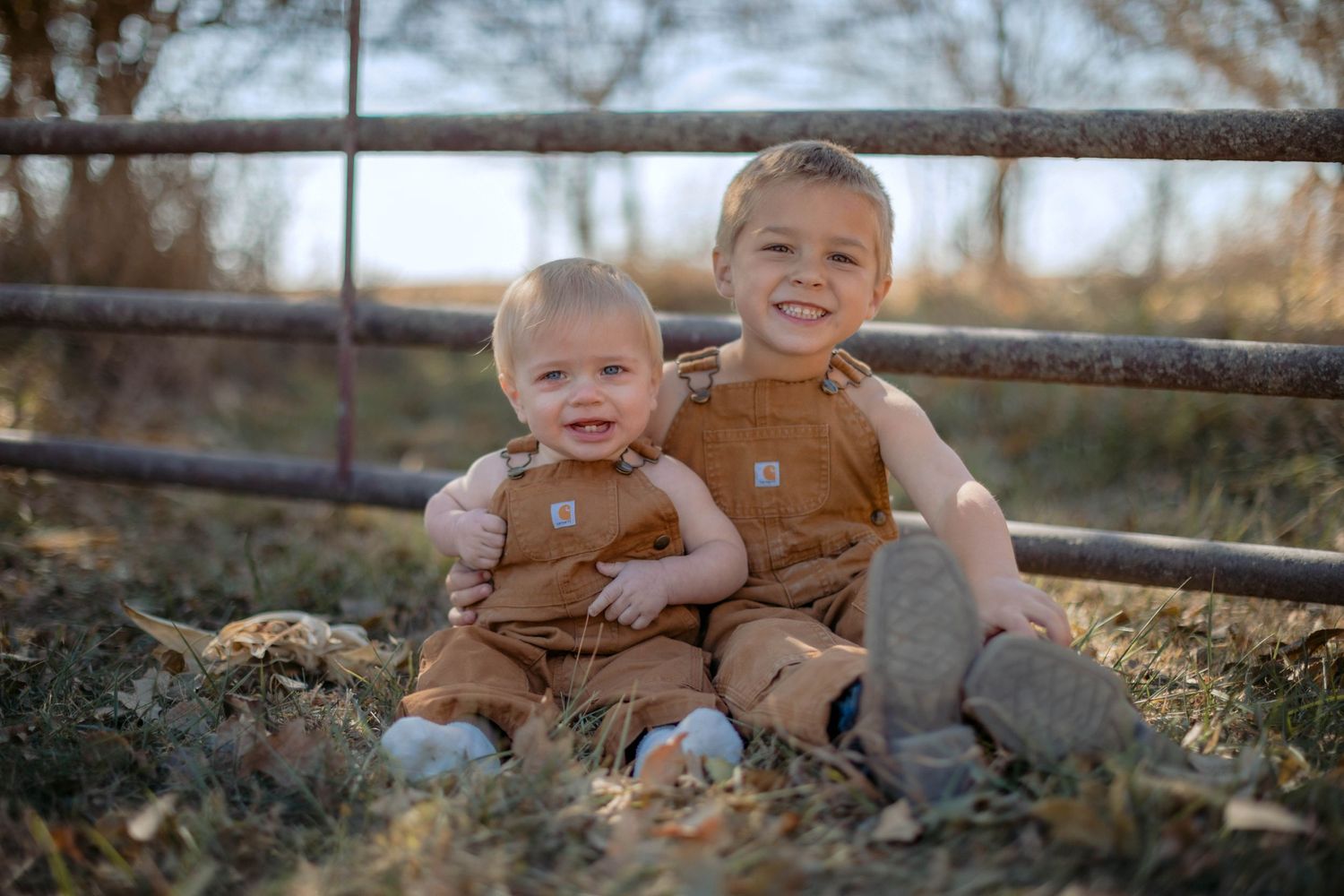 little brothers in carharrt bibs doing a fall photo shoot