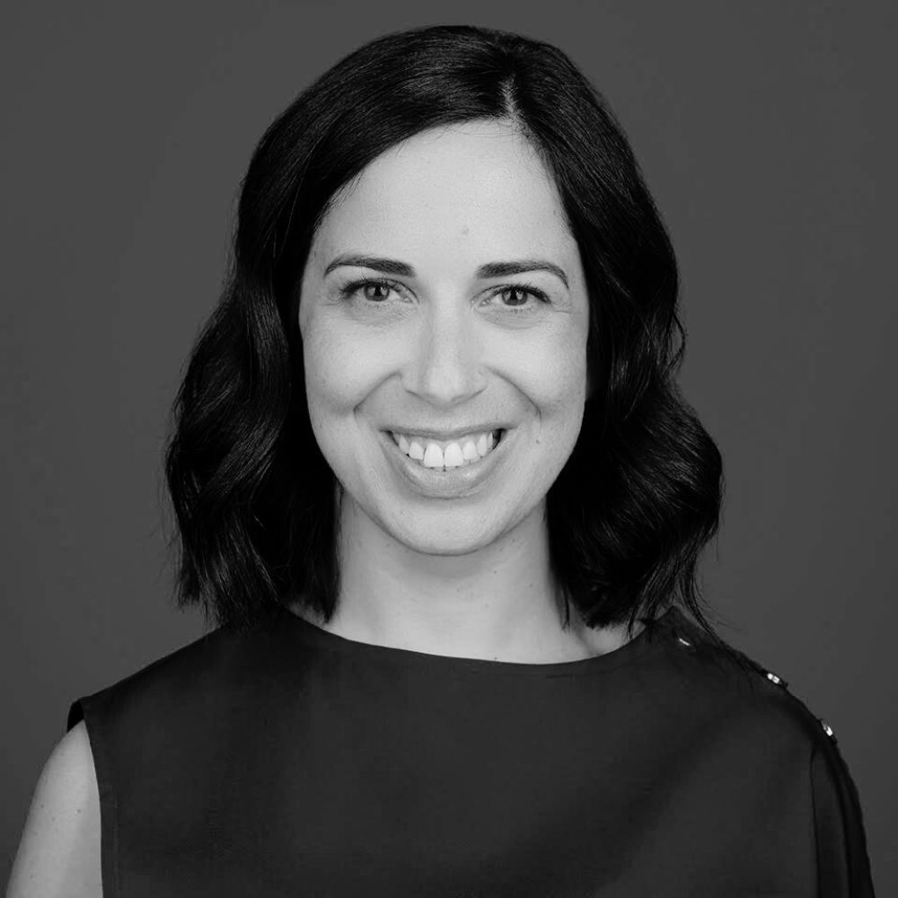 Black and white headshot portraits showing the same person with dark hair and bright smile in different poses.