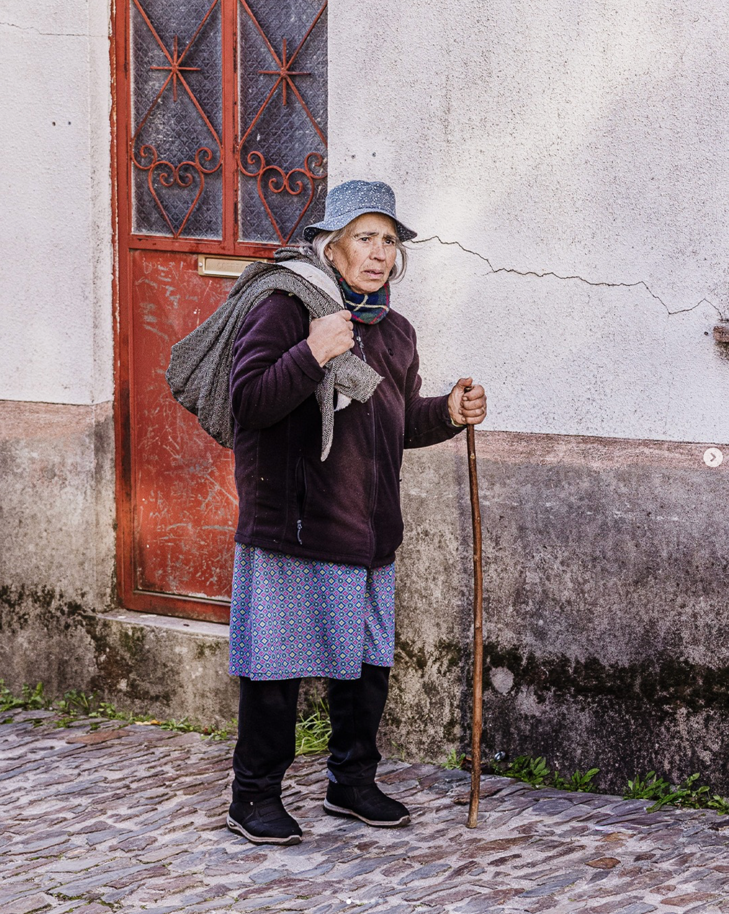 A sequence of photos showing an elderly person in traditional clothing leaning on a walking stick against a rustic wall.