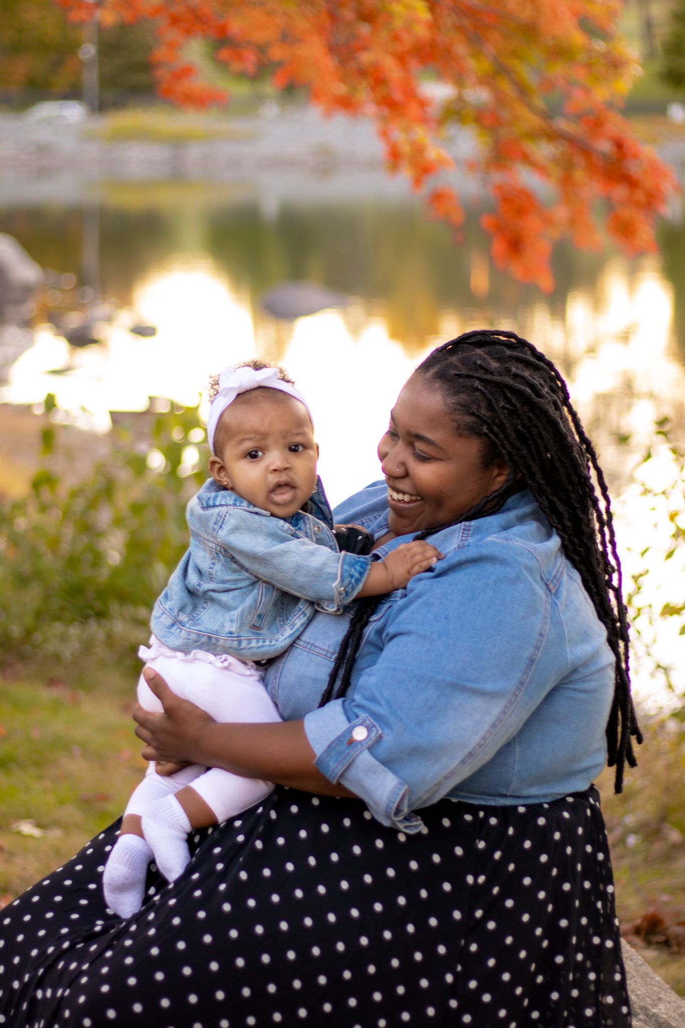 Autumn portrait by lake with fall foliage and golden light reflections.