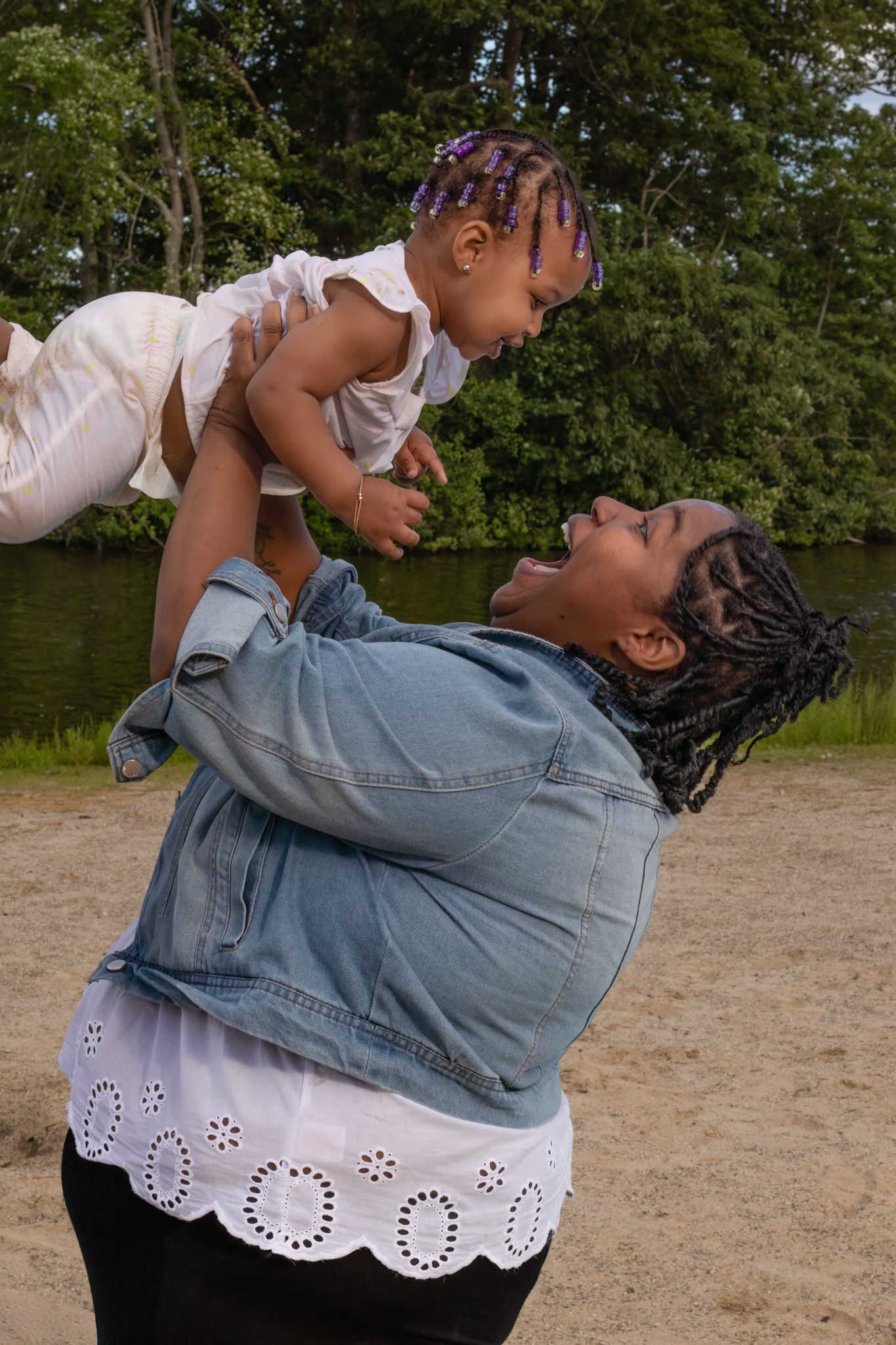 Candid outdoor photo of parent and child playing and laughing together.
