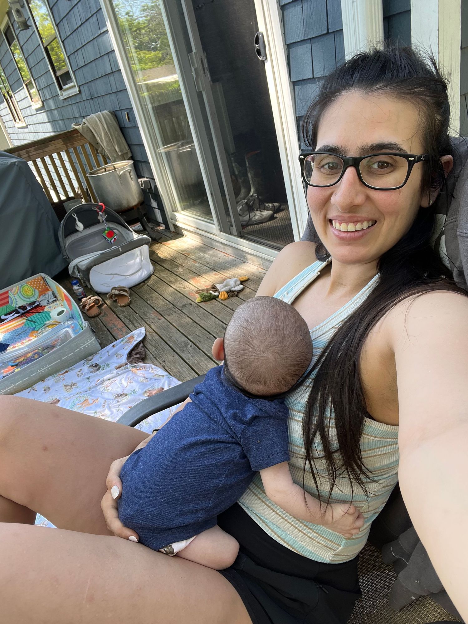 A casual moment captured on a wooden deck shows parent and baby bonding time.