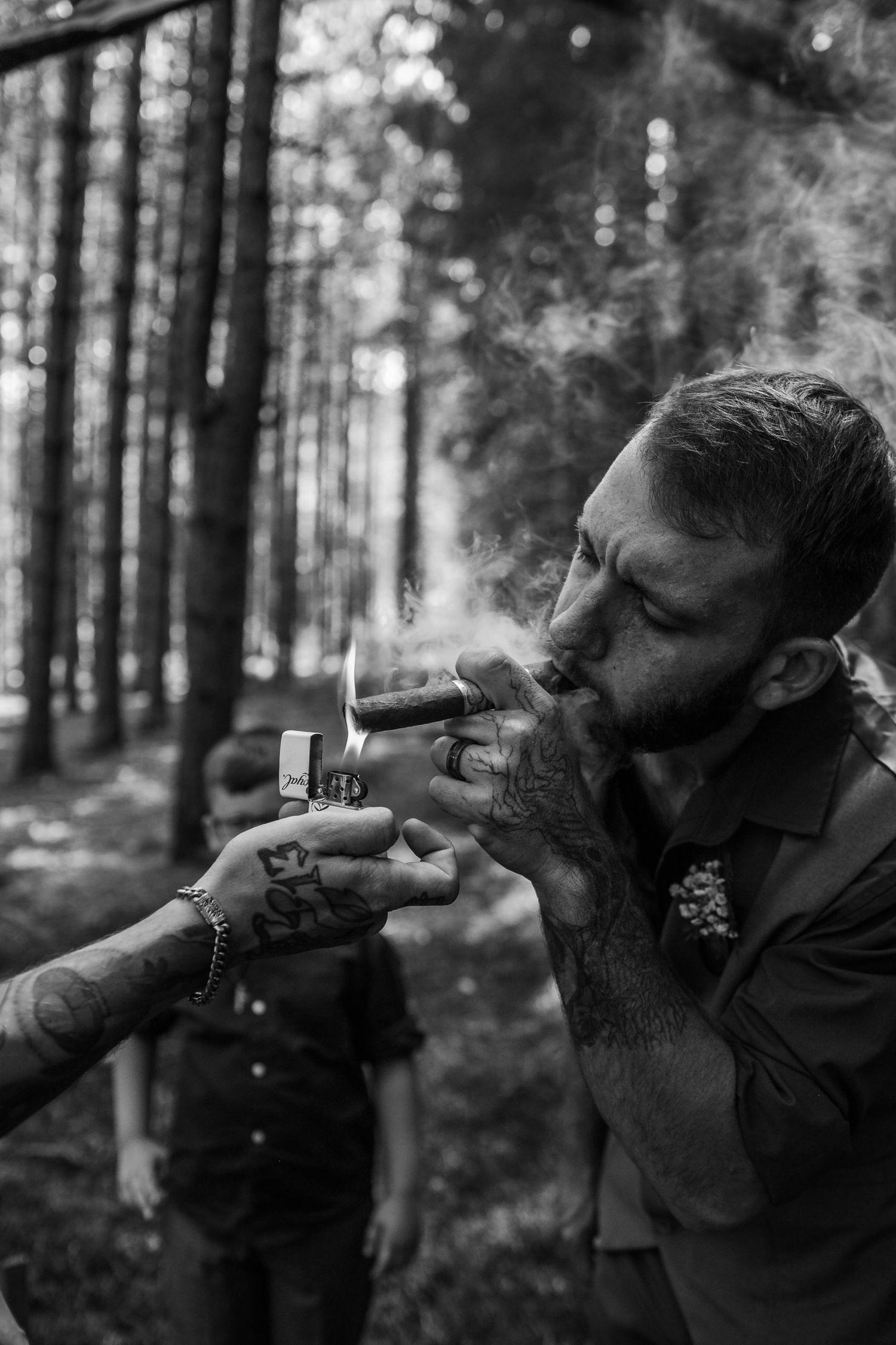 Black and white series of someone smoking a cigar in a forest setting.