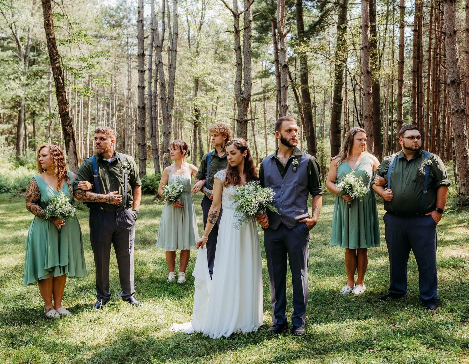 Wedding party in sage green and navy attire poses together after a beautiful Tionesta morning wedding.