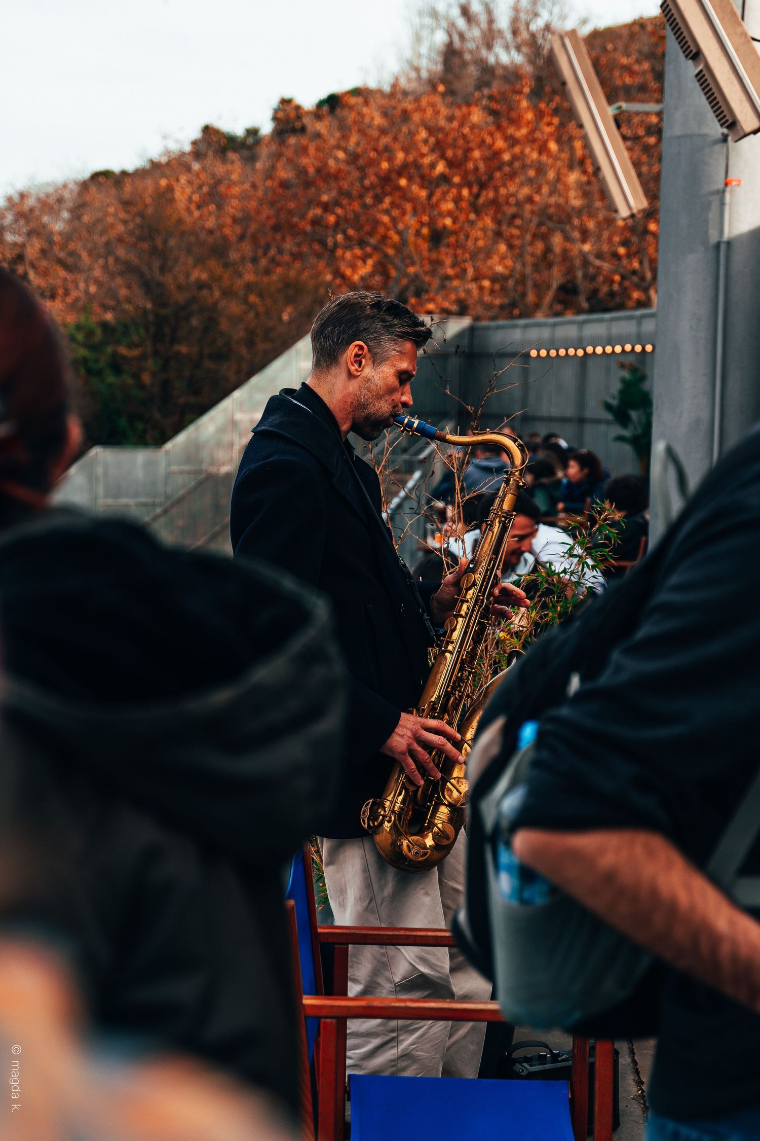 A street musician playing the saxophone, lost in the rhythm of the music.