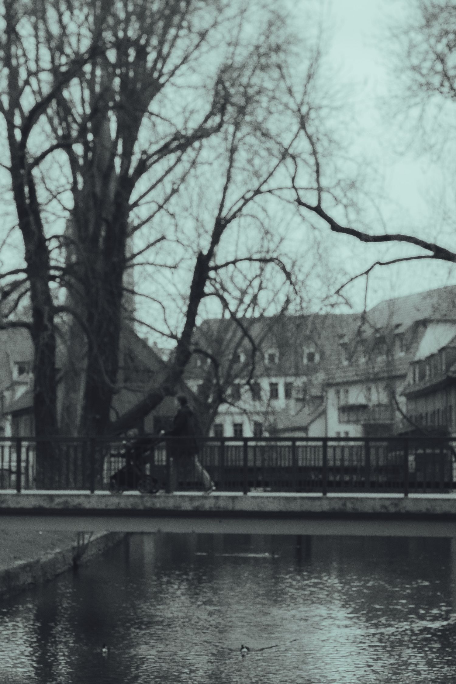 A figure walking across a bridge.