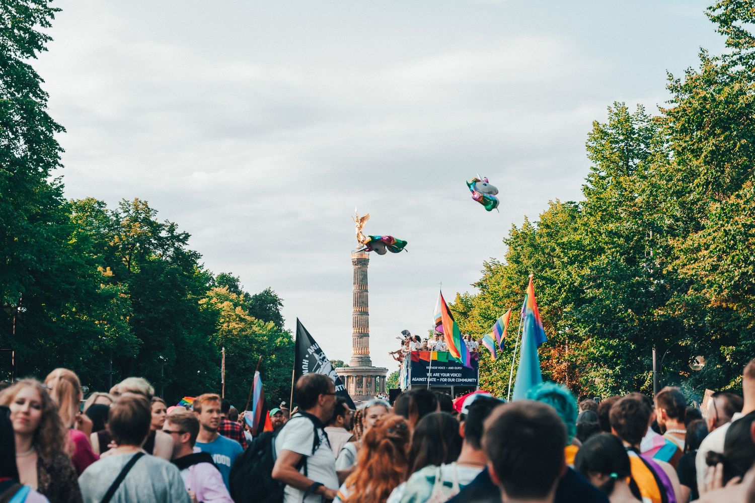 Protest scene at Berlin. A group of demonstrators holding signs with messages about Queer Rights.
