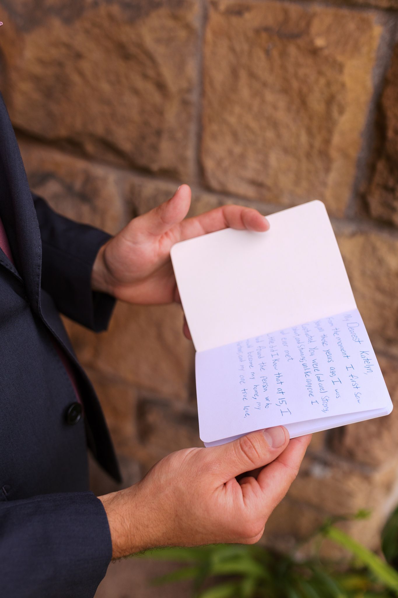 close up look of a grooms handwritten vow book before private first touch with bride