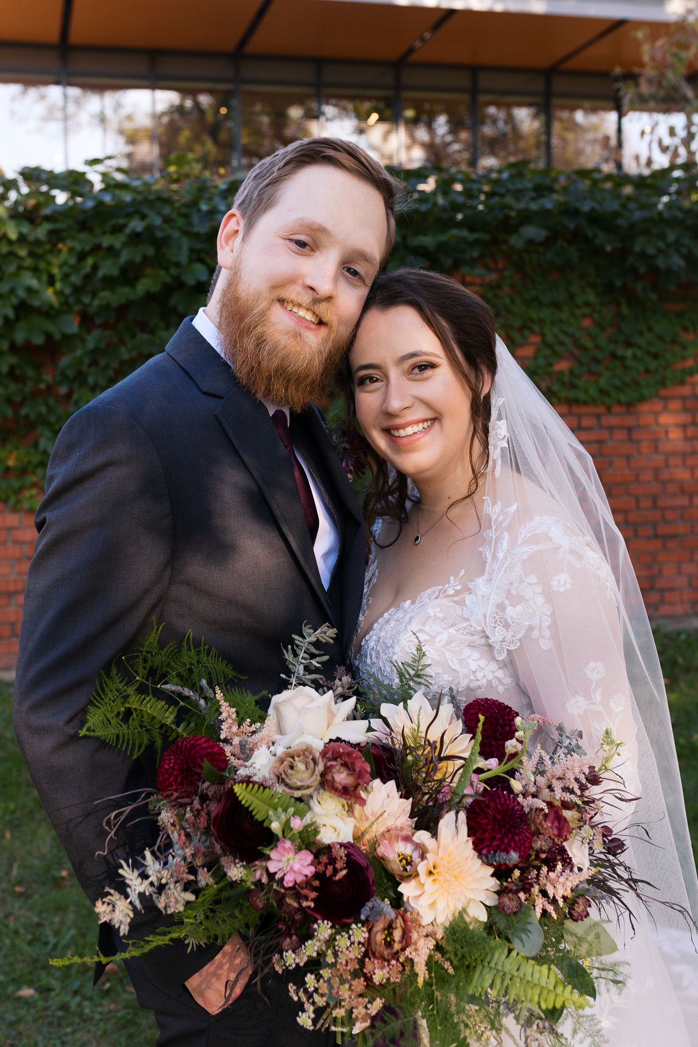 Bride and groom smile at Pittsburgh wedding photographer, Emma Craven, while standing outside The National Aviary