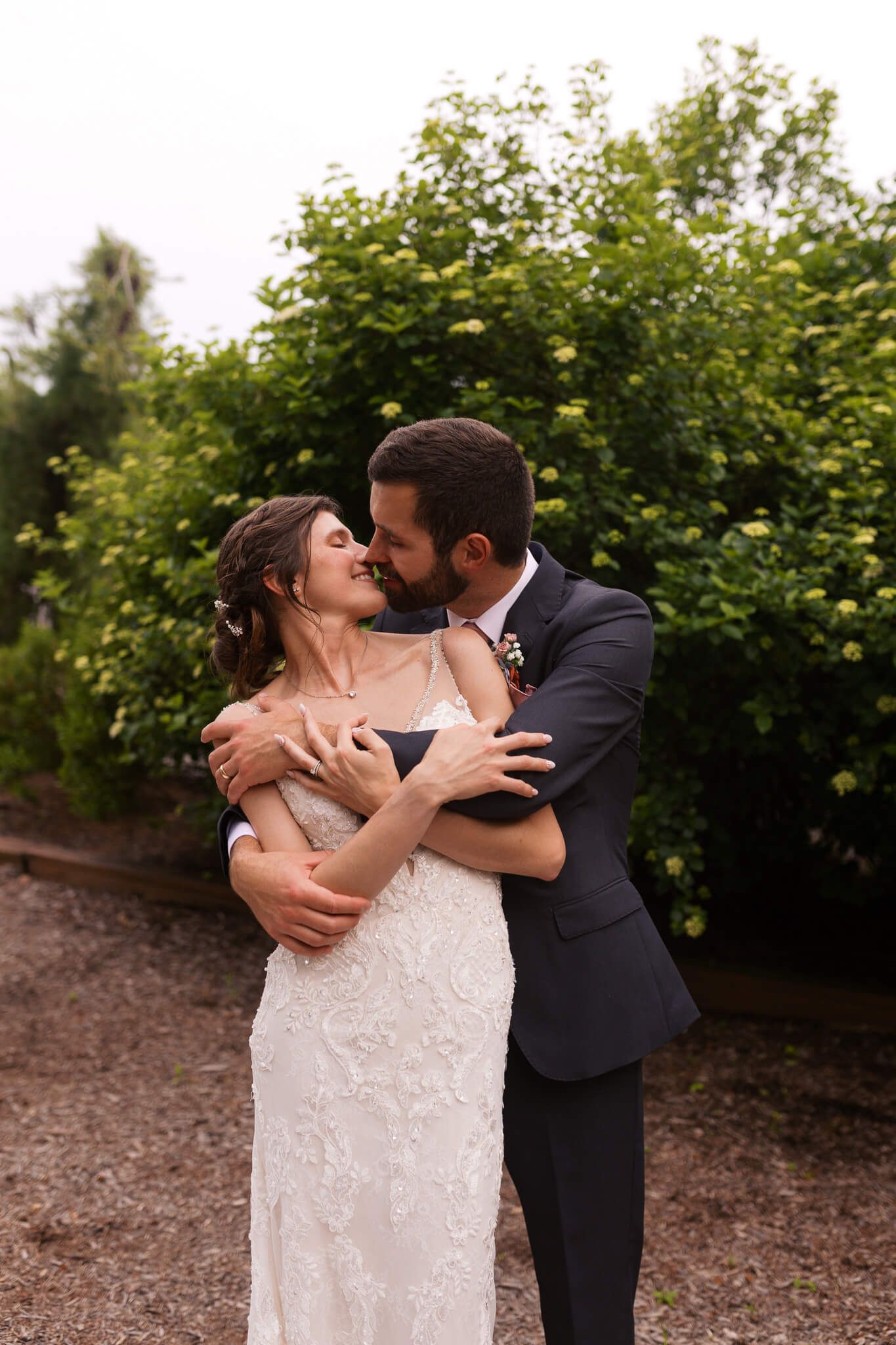 man hugging wife while she has her arms on his and their faces are nuzzling