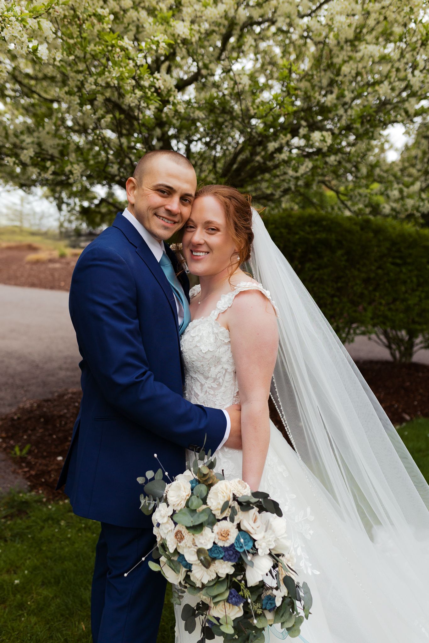 Couple smiling happily at Pittsburgh Wedding Photographer, Emma Craven, while standing in front of a tree blooming in spring