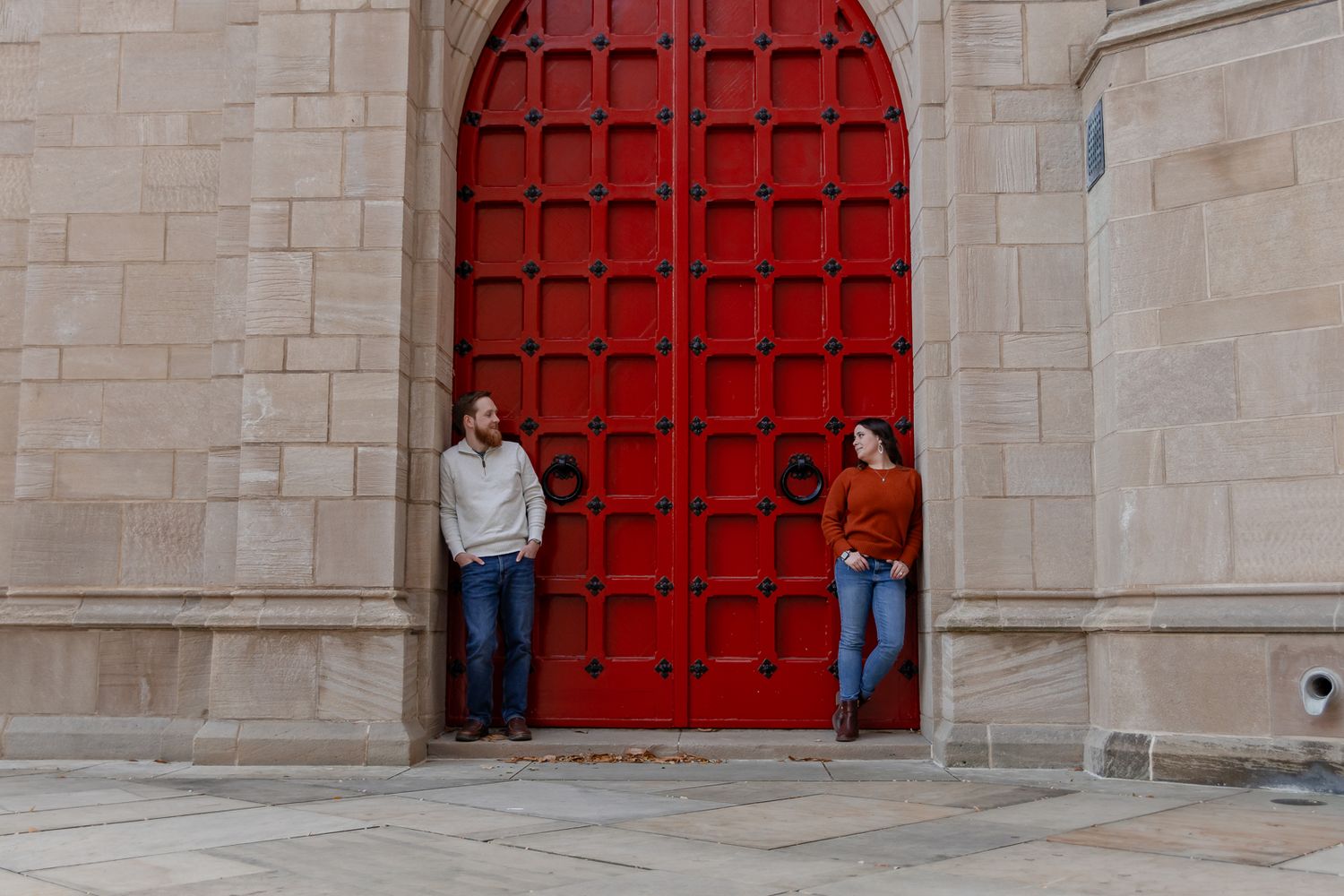 man and woman framed in red church door at University of Pittsburgh