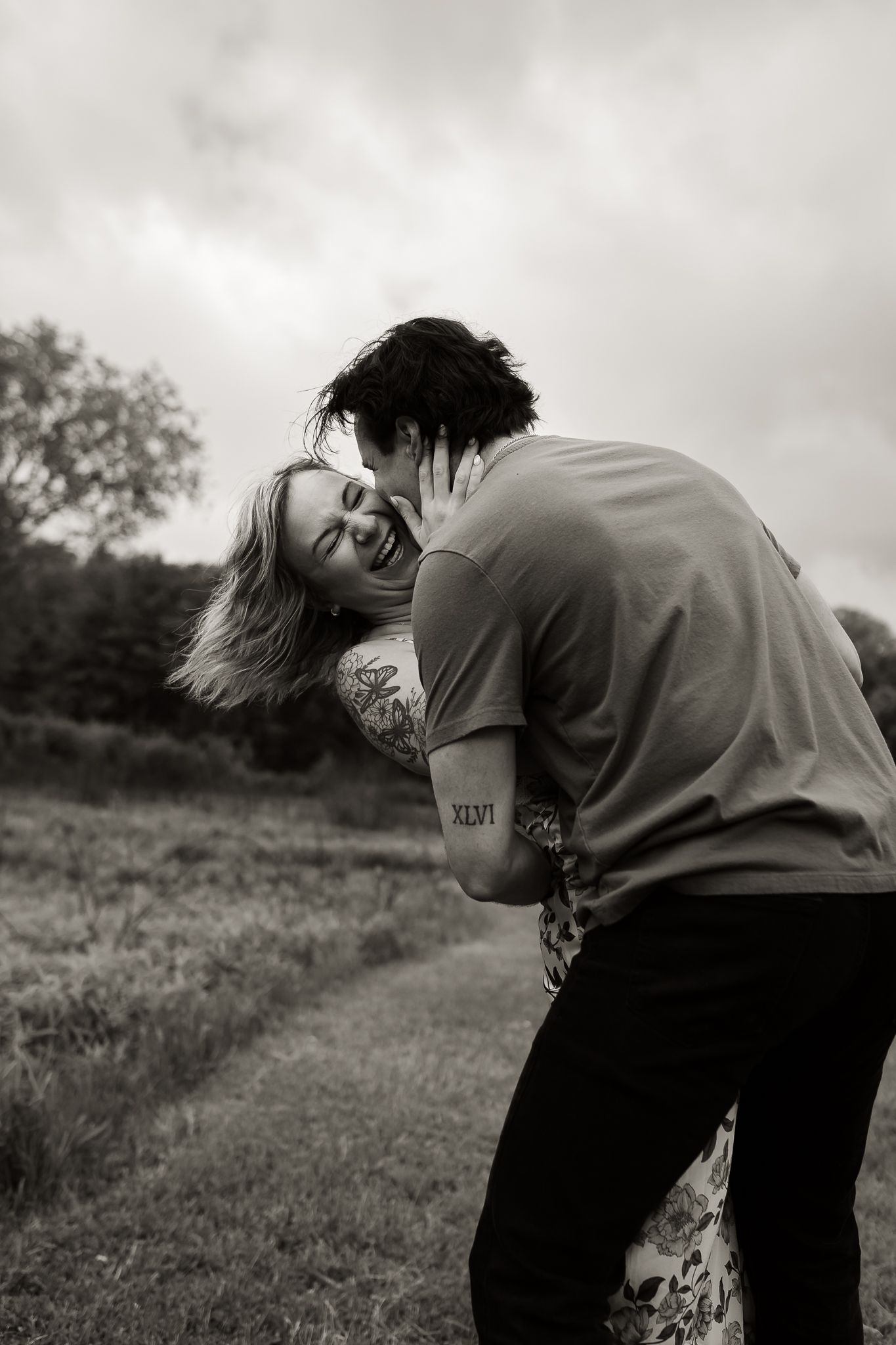 couple dancing and laughing while Emma Craven takes their engagement photos at Moraine State Park