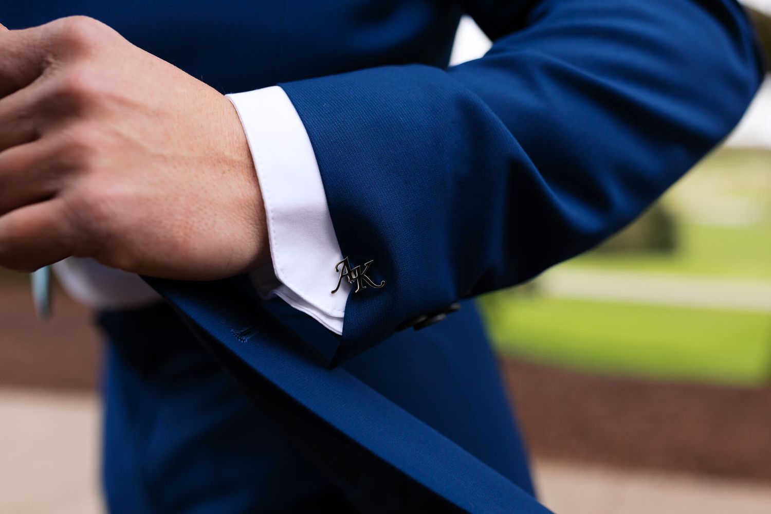 customized silver cufflinks on grooms blue suit cuffs