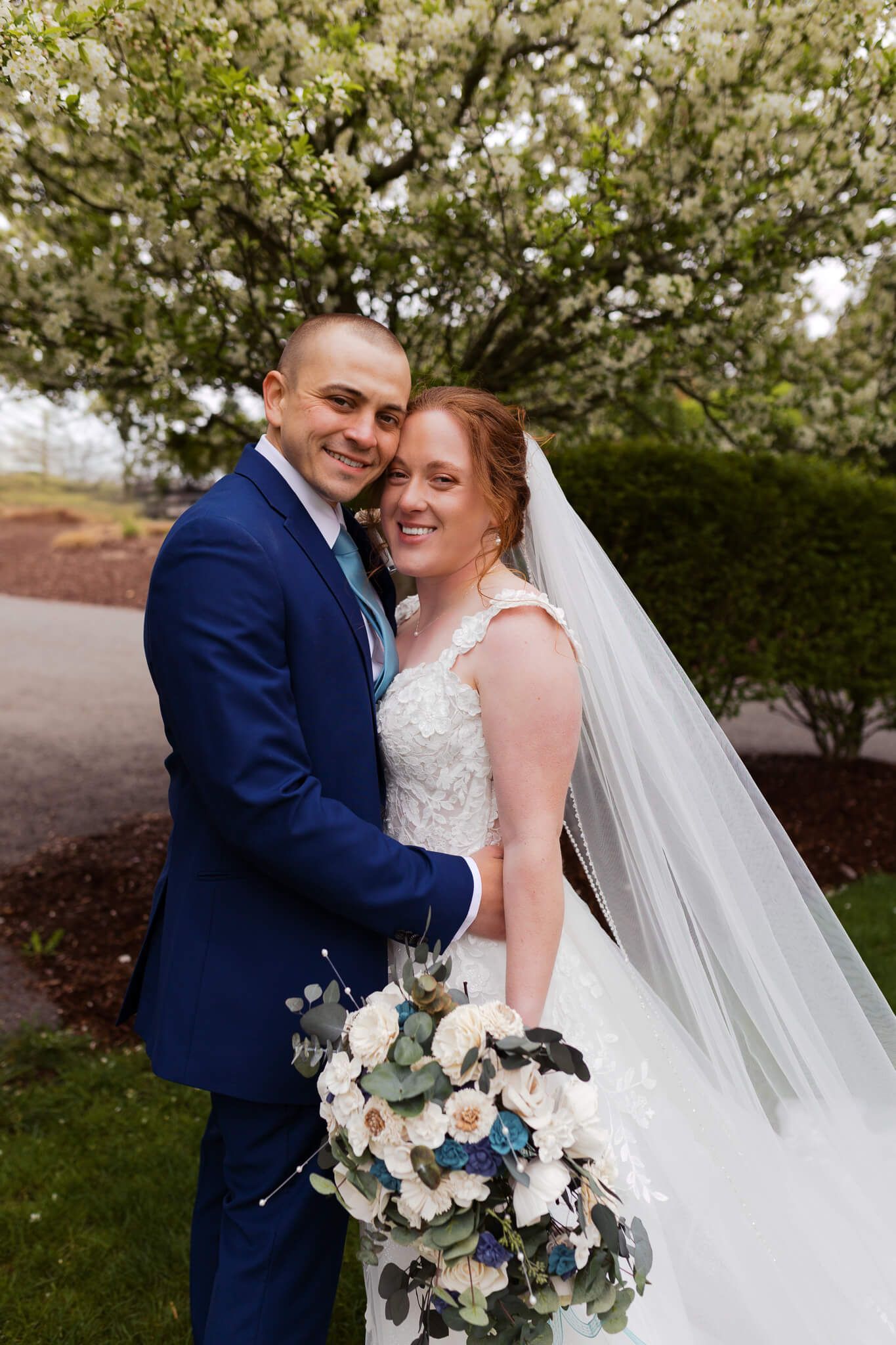 bride and groom holding each other close and smiling at the camera