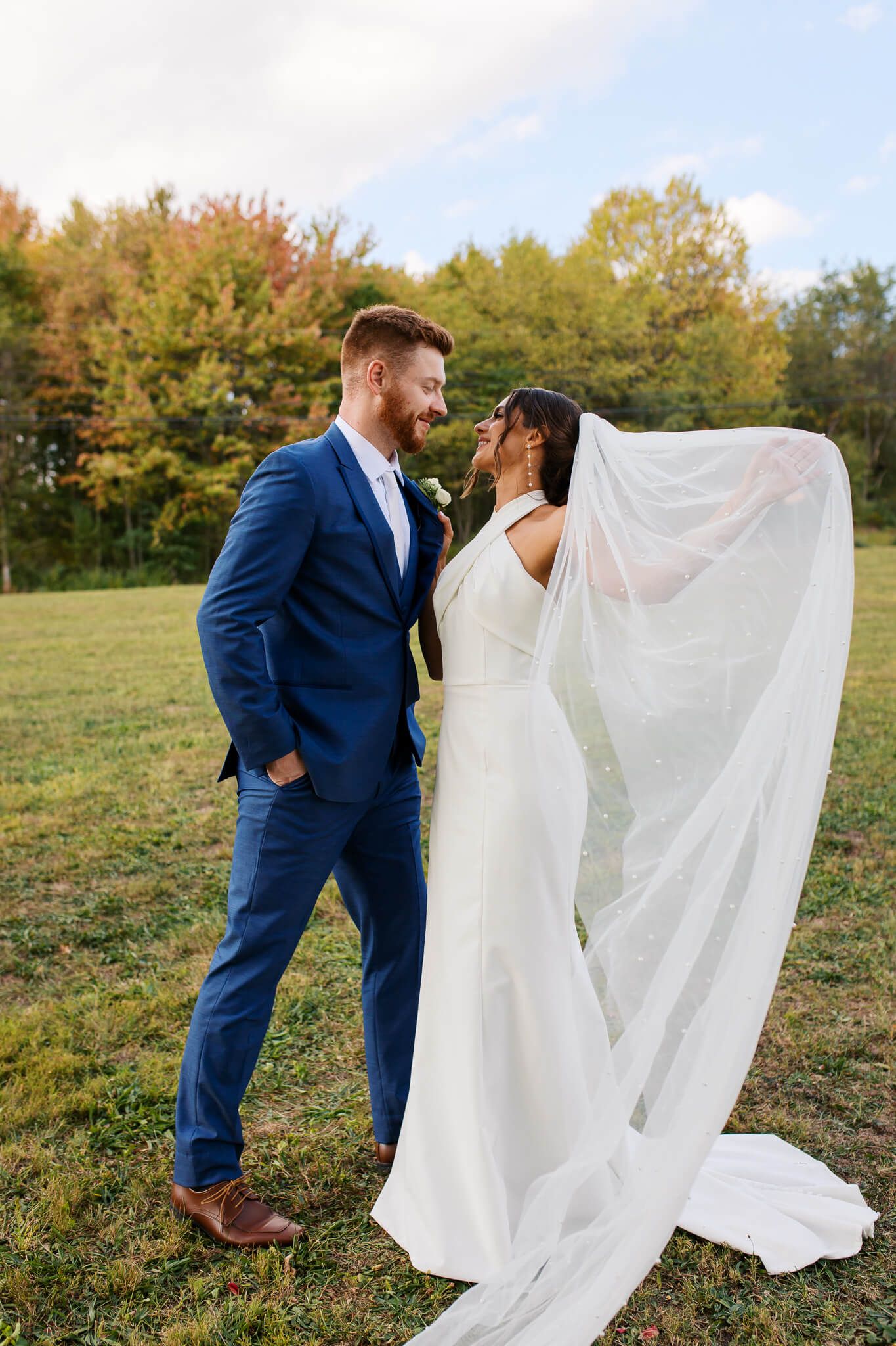 Bride with long veil swaying romantically in for a kiss from her husband