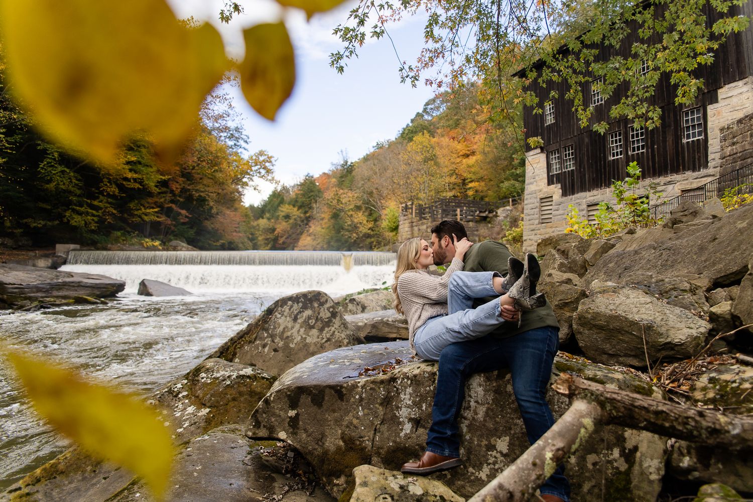 wide view of a pennsylvania waterfall with a couple sitting in front kissing