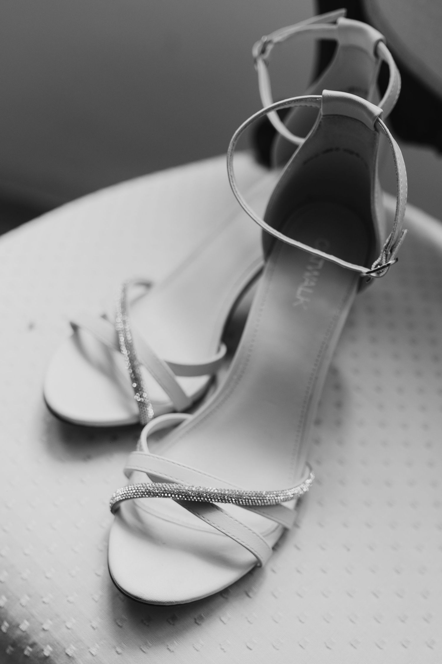 Elegant strappy bridal heels with crystal embellishments photographed in black and white.