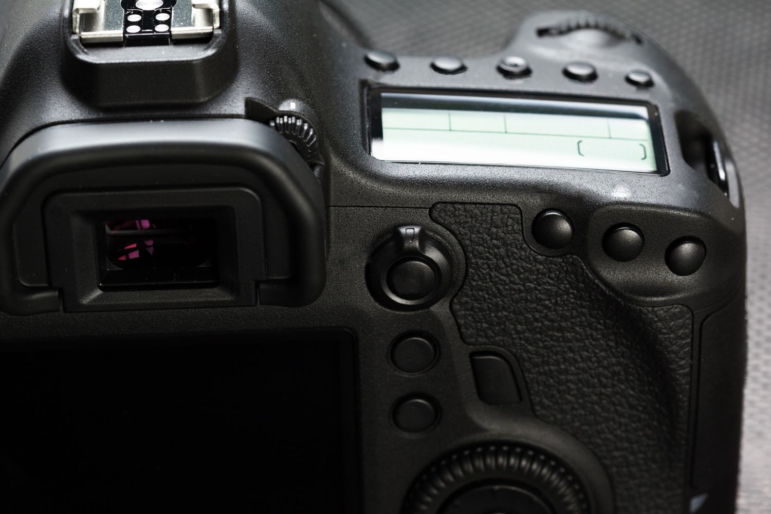 Close-up detail of a DSLR camera's viewfinder and control buttons.