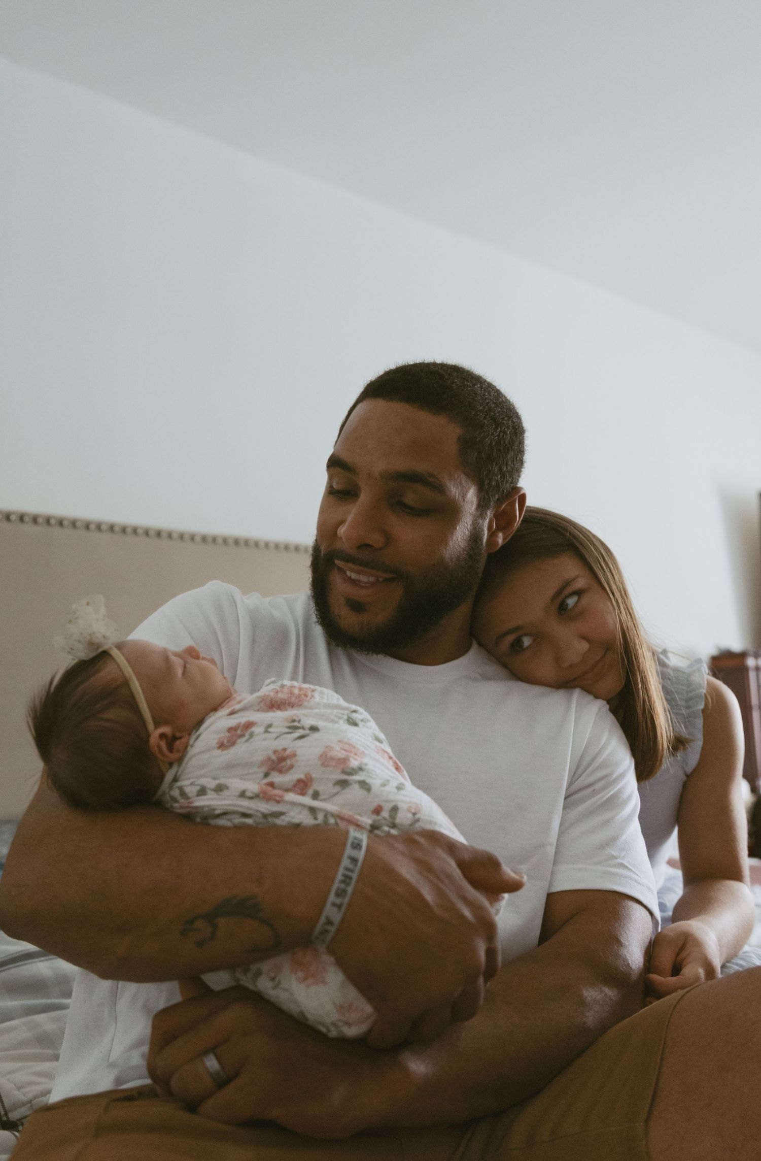 Dad and daughter looking at newborn baby on the bed during an in-home photoshoot in Sussex County New Jersey