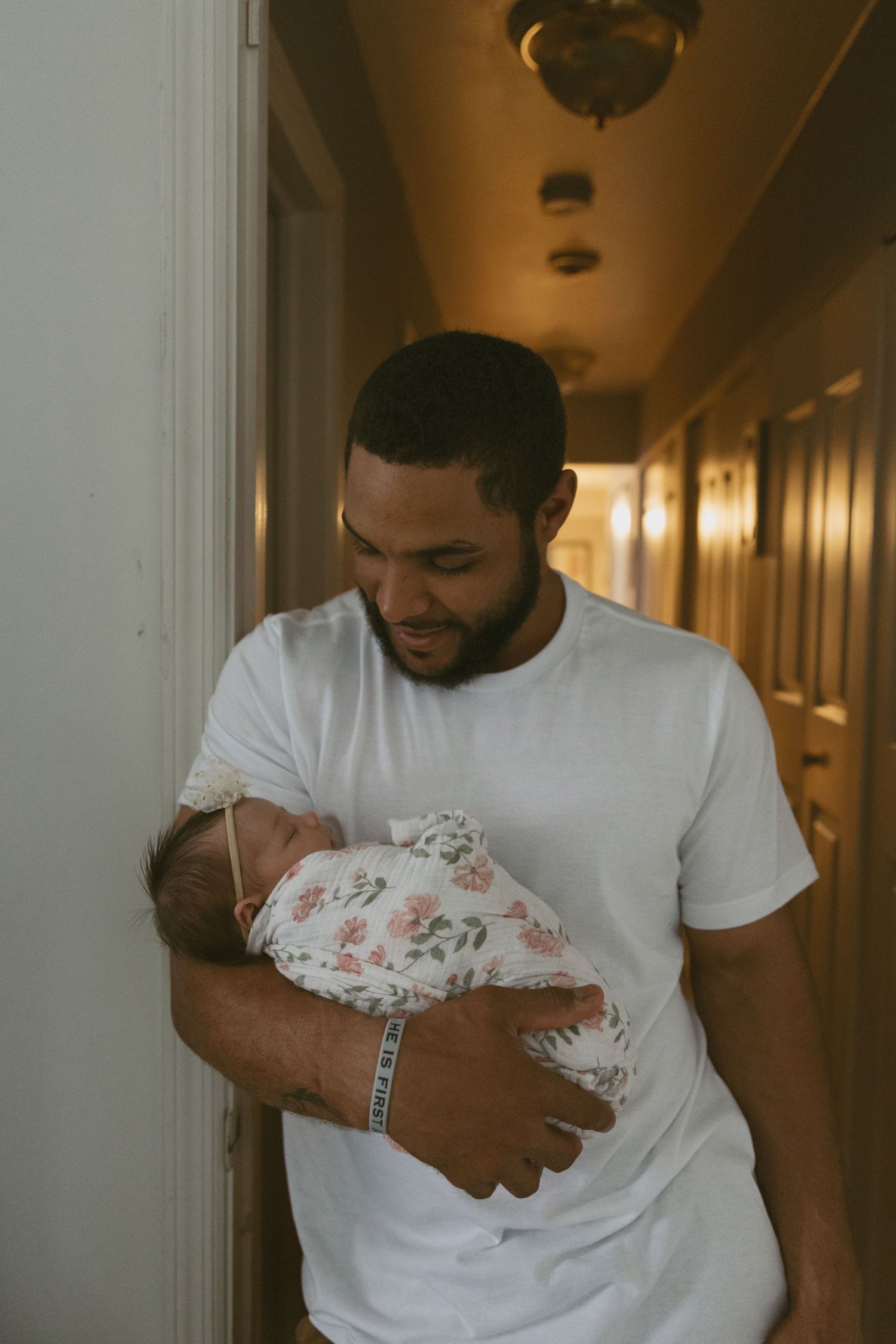 Dad holding his newborn baby in the door frame during a newborn in-home photoshoot in Sussex County New Jersey.