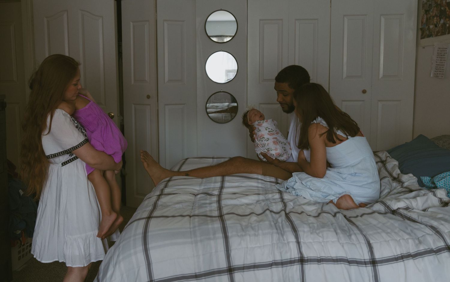 The in-between moments of a mother caring for her toddler during a newborn in-home photoshoot.