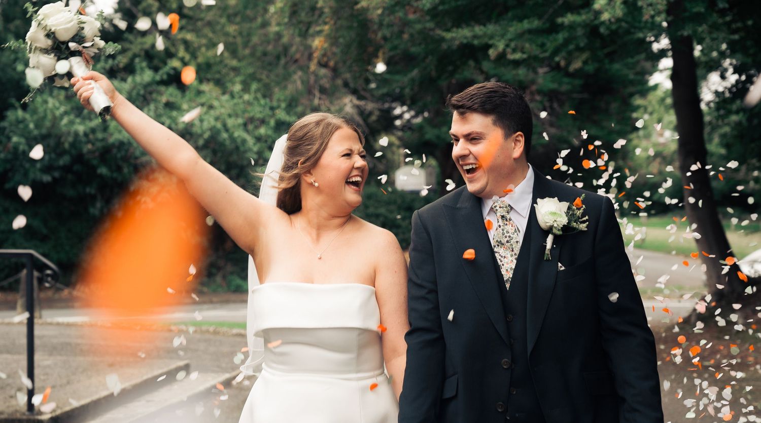 just married couple cheer with bouquet after the ceremony