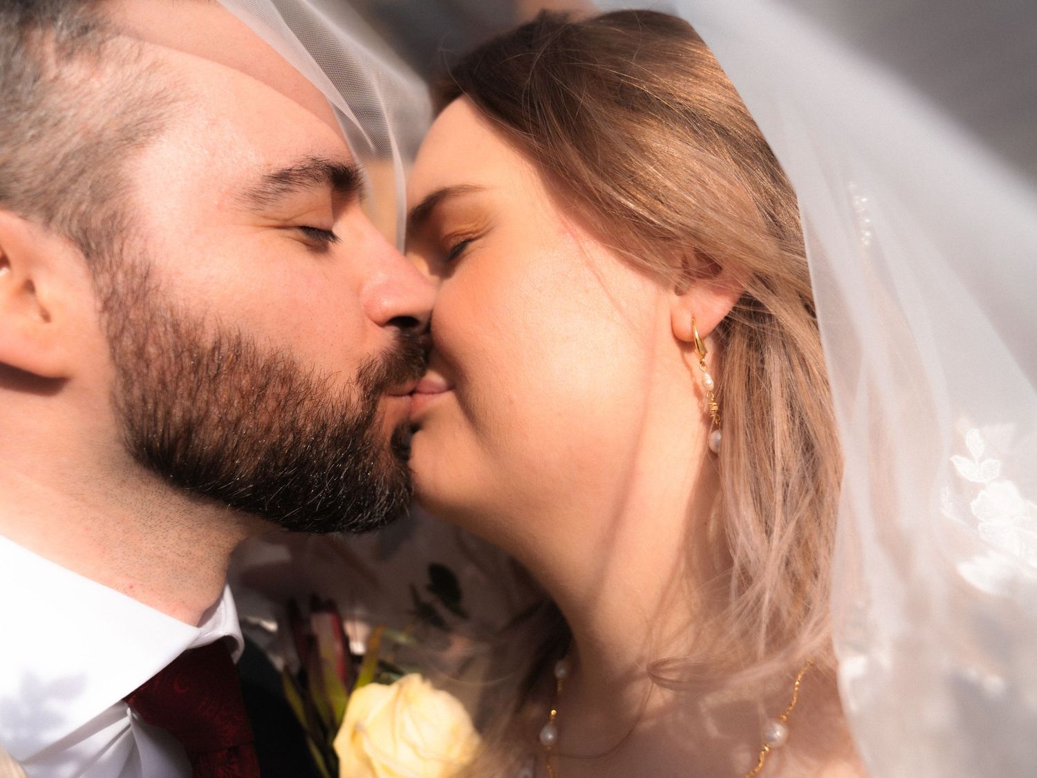 under-veil shot of a newly wed couple kissing