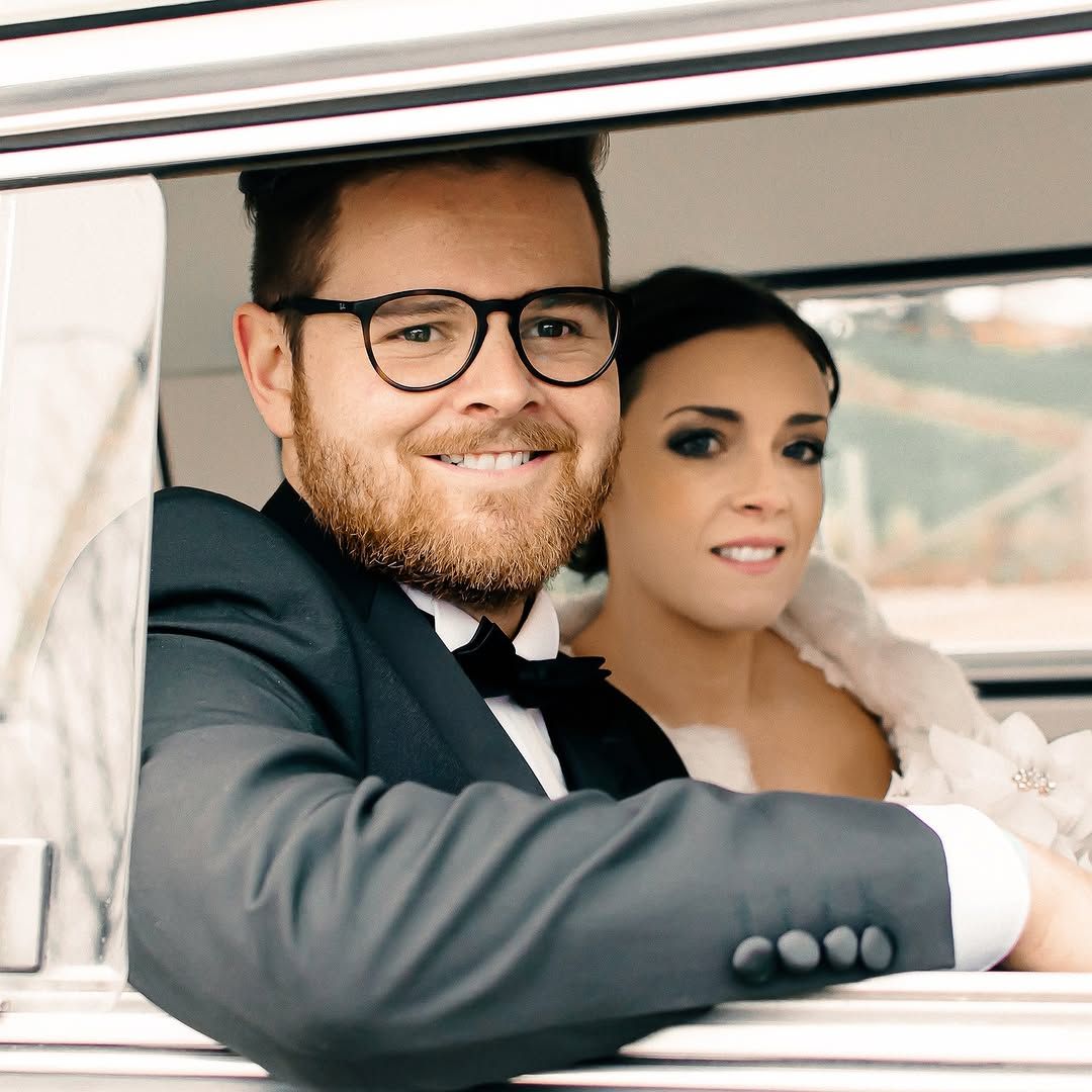newly wed couple smiling in a car