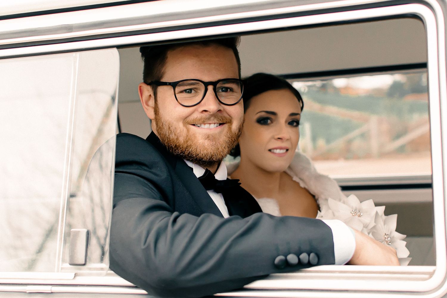 newly wed couple smiling in a car