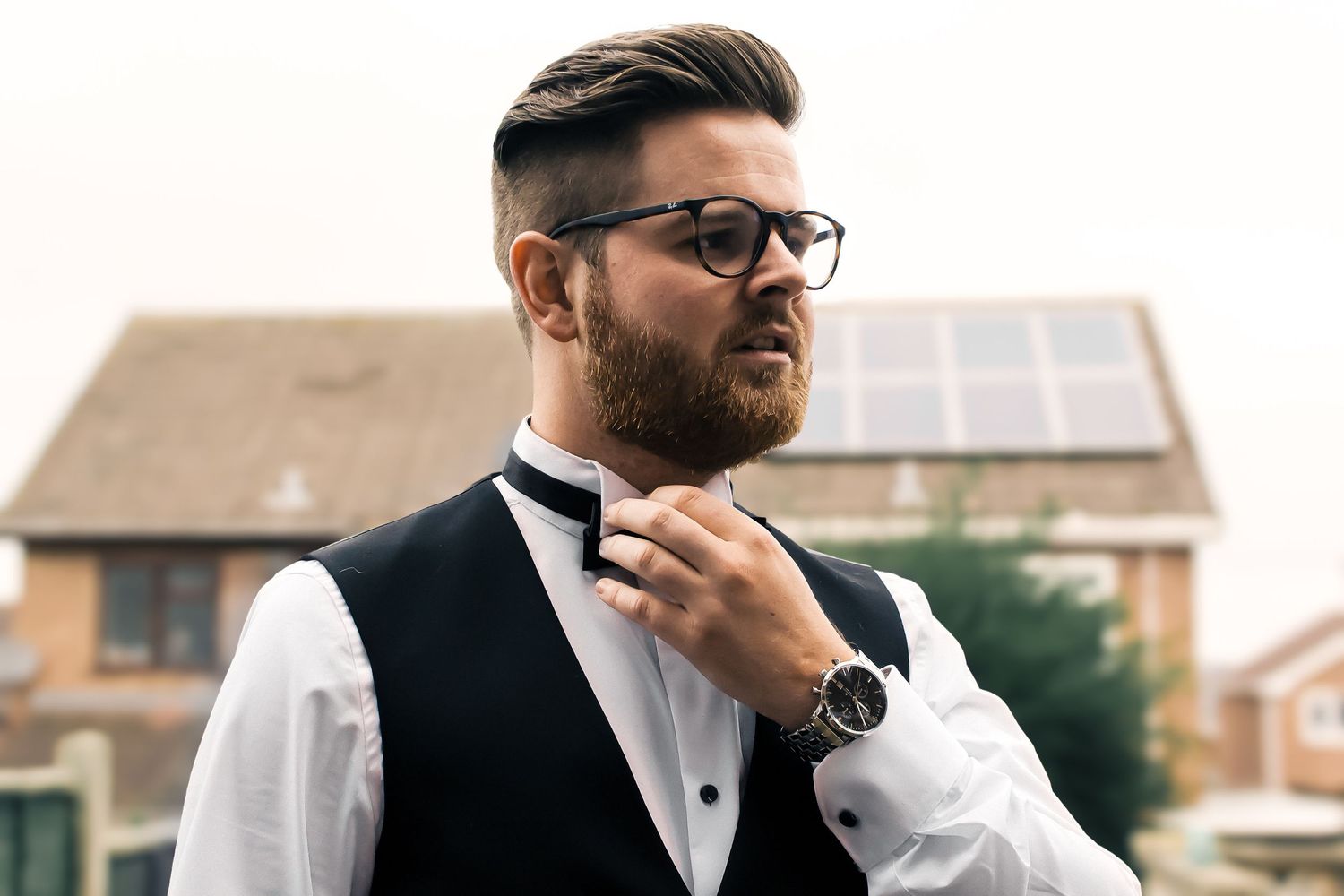 groom adjusting bow tie in his garden before the wedding