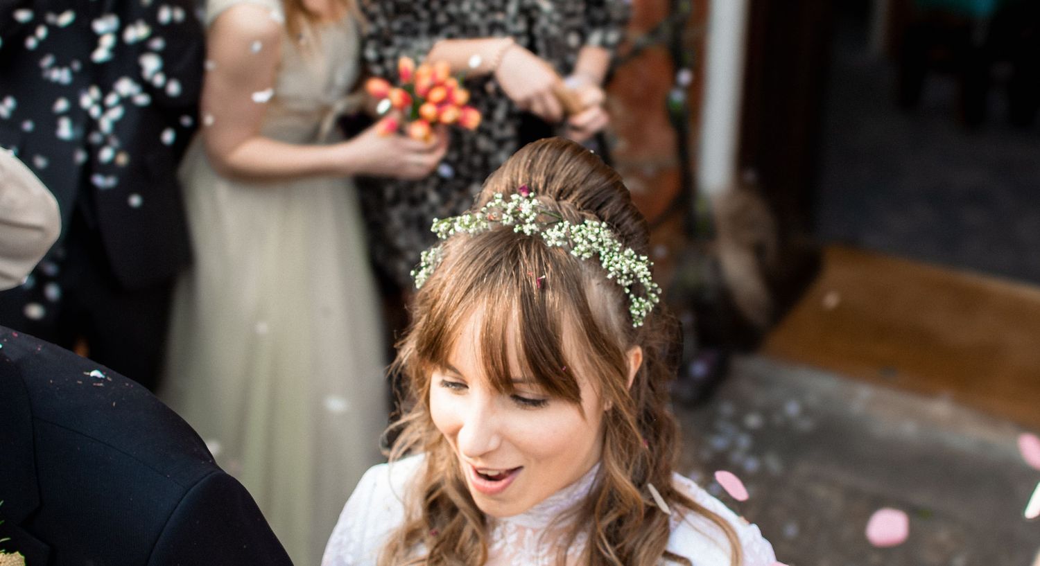 artistic top-down shot of the bride under a confetti shower, showing her happy expression.