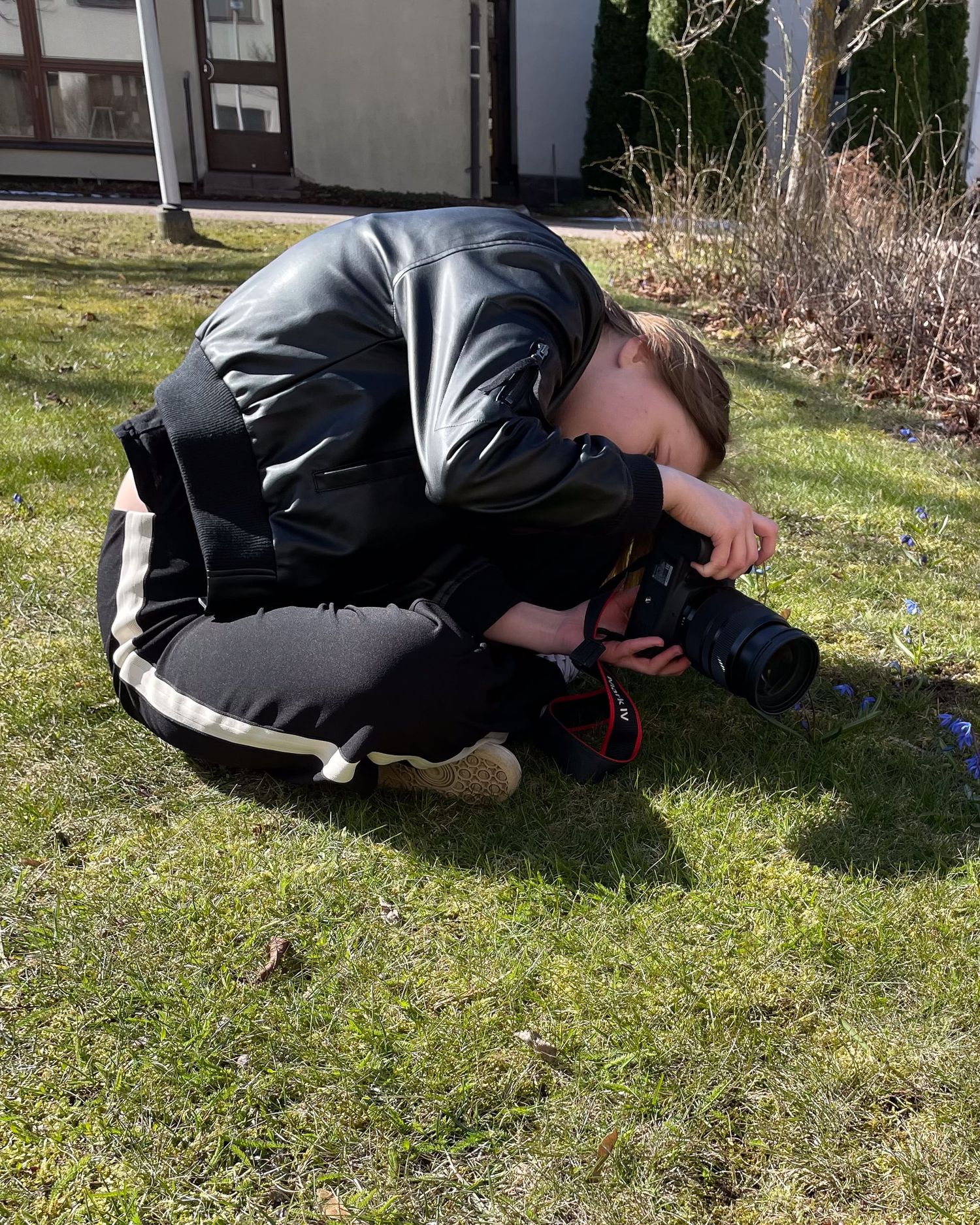 Henni Valokuvaaja / Henni Leskinen kuvaamassa kukkia maassa