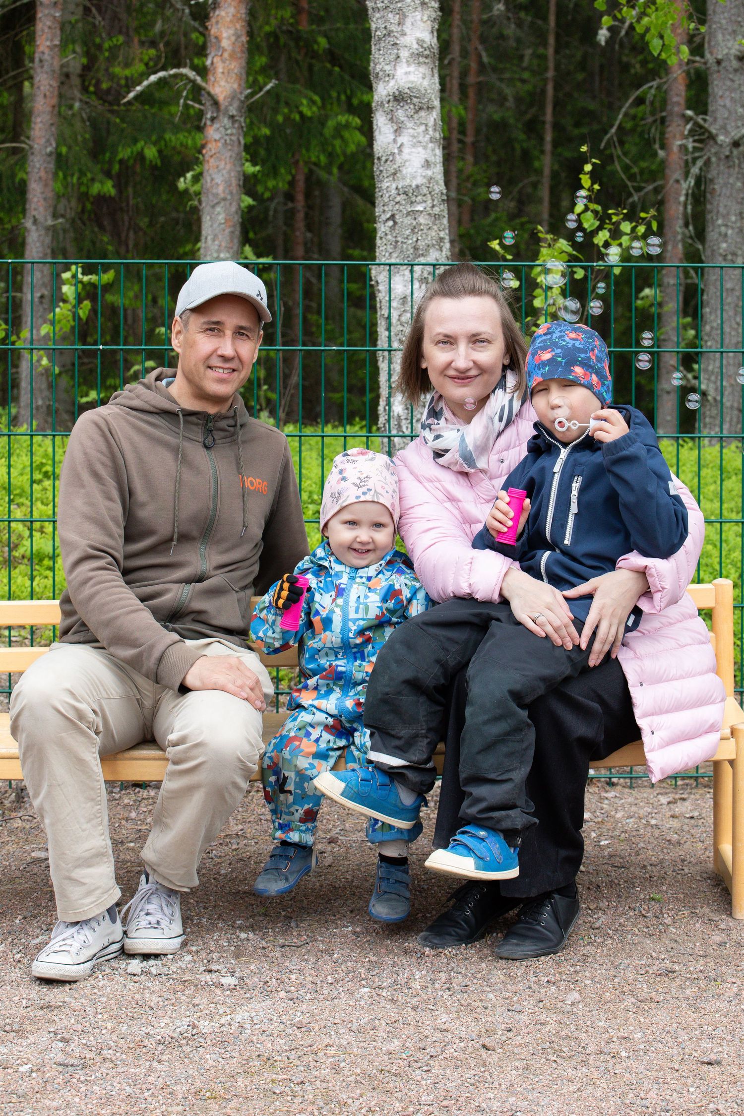 Perhe istuu penkillä miniperhekuvauksessa.
