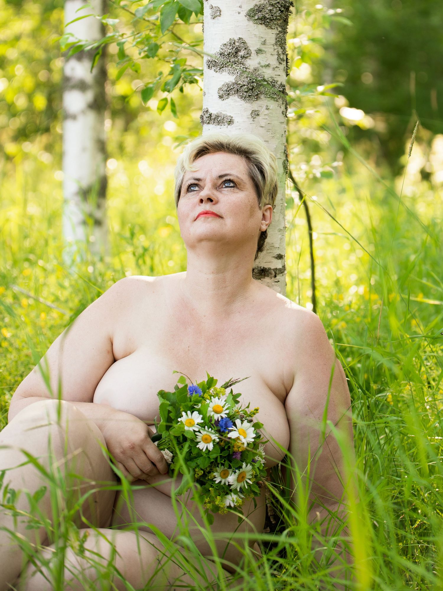 Boudoir-kuvaus luonnossa, nainen istuu metsässä