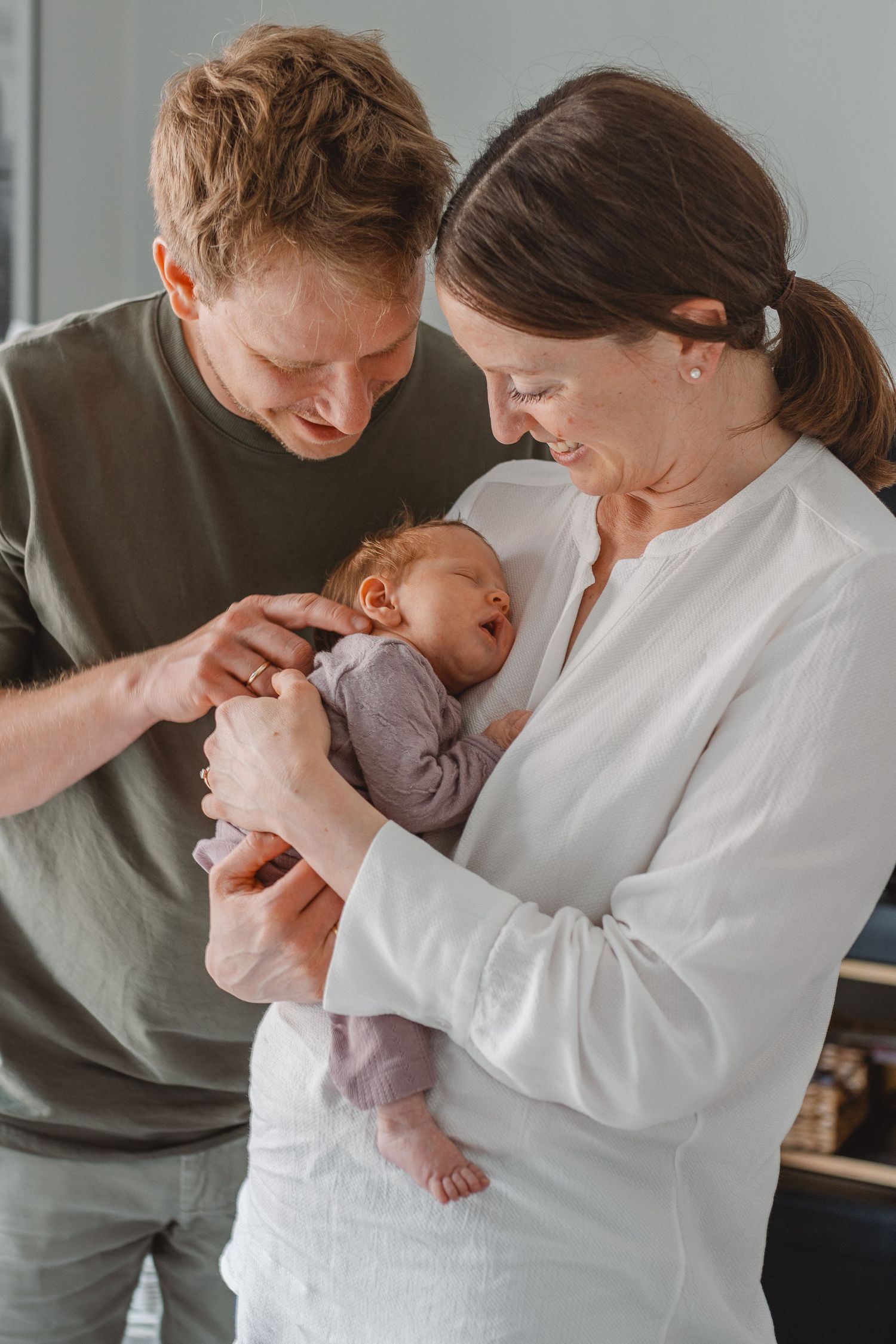 A series of tender moments between parents and their infant baby in candid lifestyle portraits at home in Newport Beach.