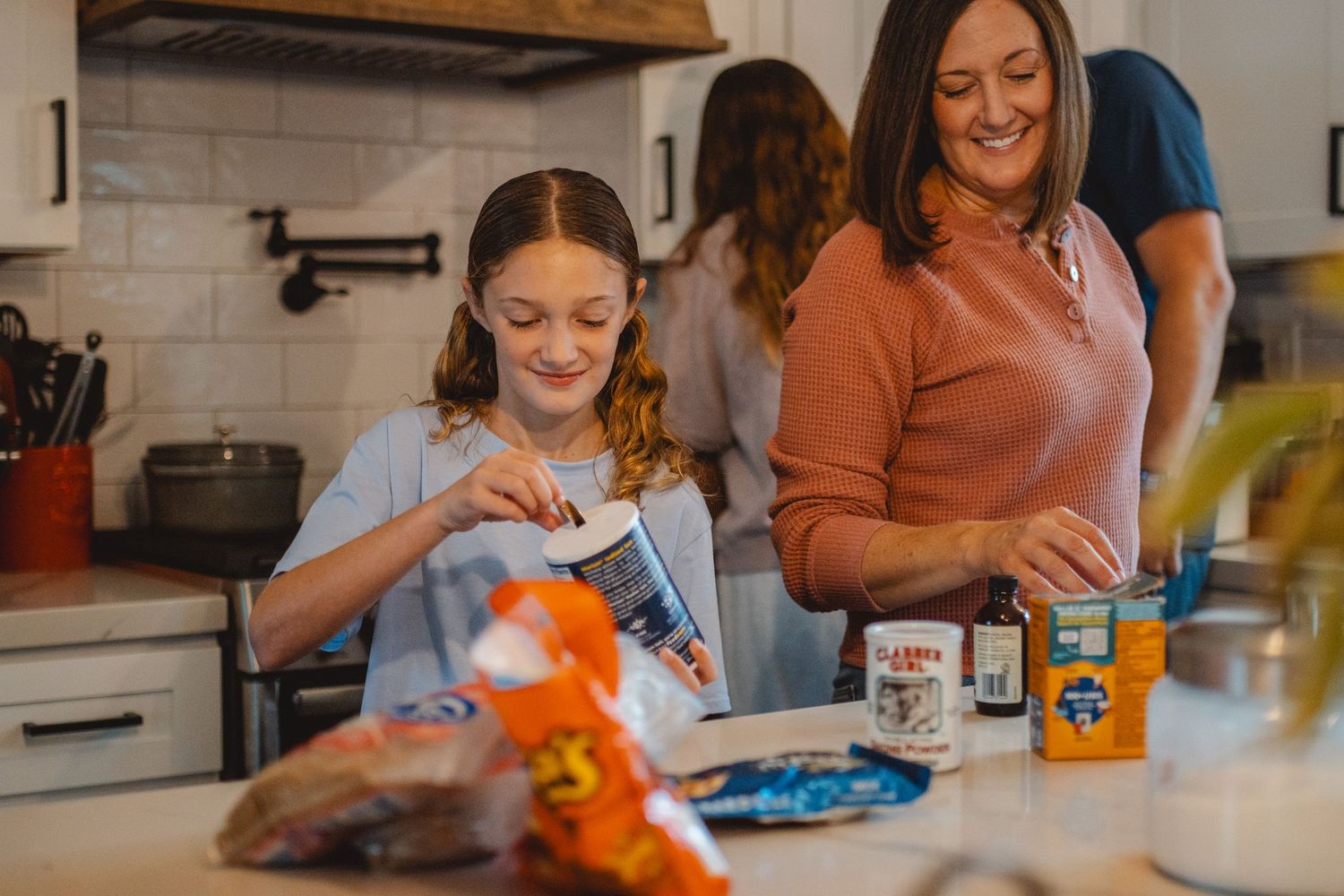 A parent and child work together on a hands-on craft project at a kitchen table with art supplies in Huntington Beach.