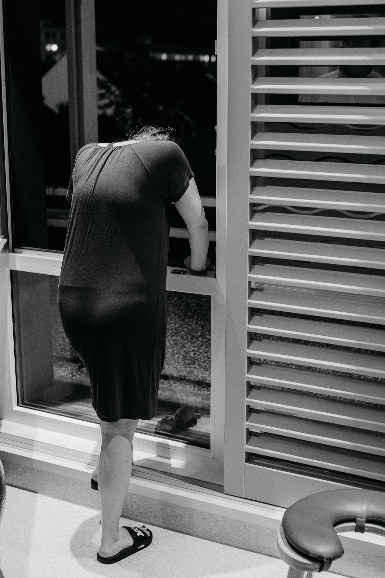 A black-and-white image of a woman from behind, taking a breath of fresh air during childbirth in Huntington Beach.