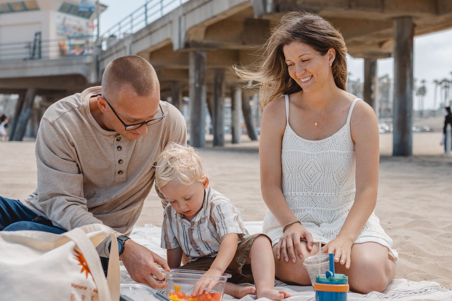 People enjoy family time spending quality moments together eating watermelon on the beach in Newport Beach.