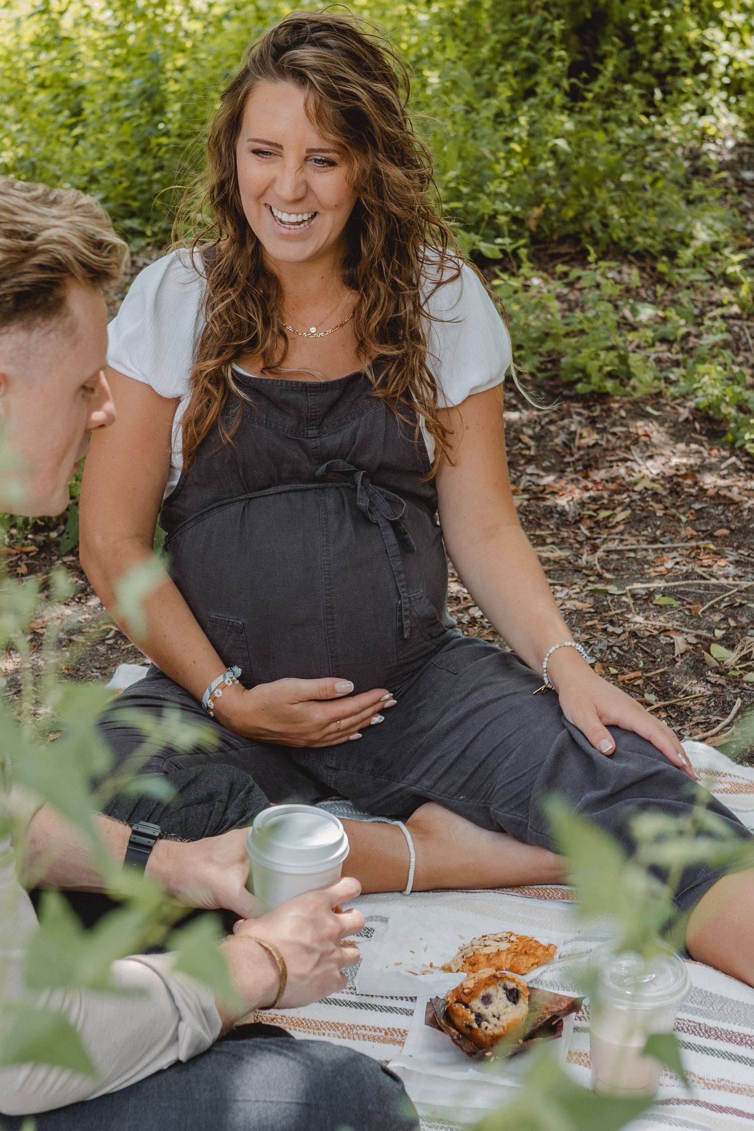 Sweet couple having refreshments and food together on casual outdoor picnic blanket in nature setting in Laguna Beach.
