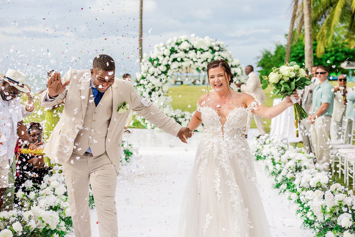 Wedding celebration with confetti flying through air as couple celebrates outdoors.