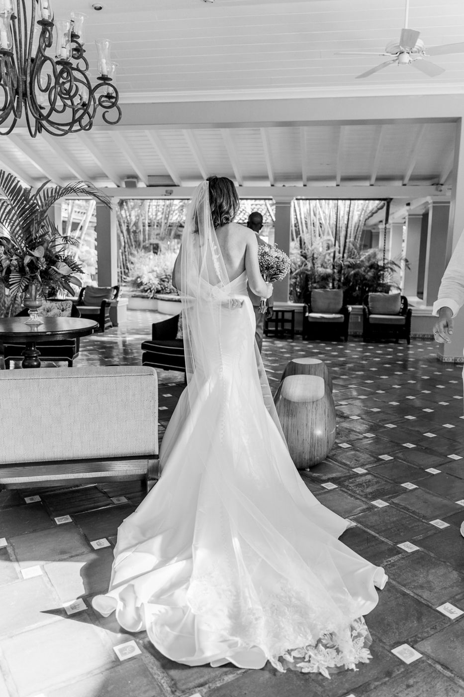 Wedding dress details shown in black and white on tiled floor interior.