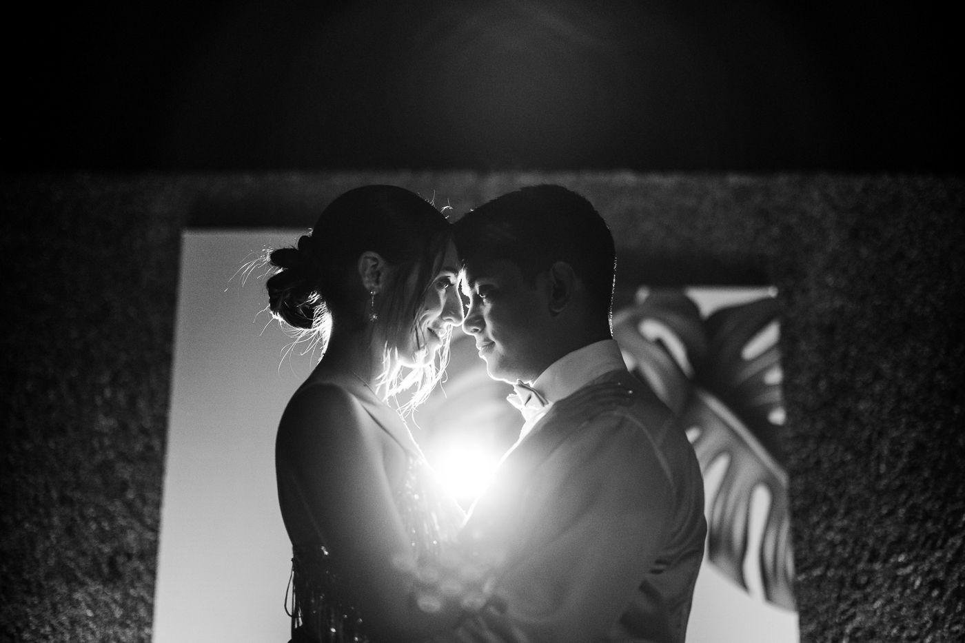Dancers in formal attire create silhouettes against dramatic lighting during a performance.