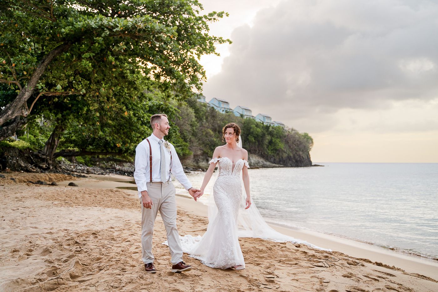 Romantic beach wedding photo with mountains and ocean in the background.
