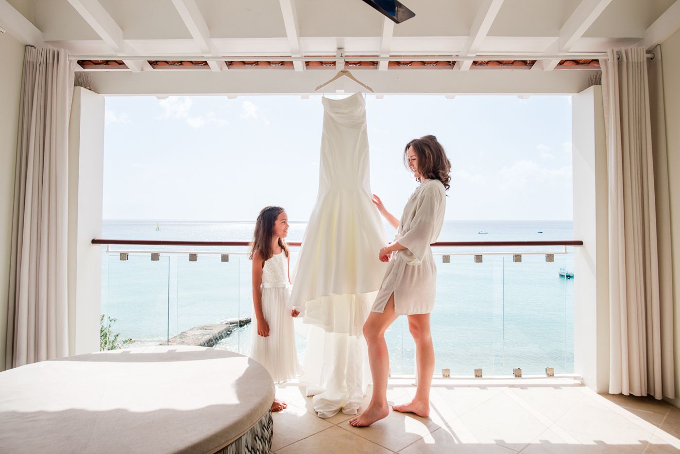 Bright oceanview room with white curtains and natural lighting.