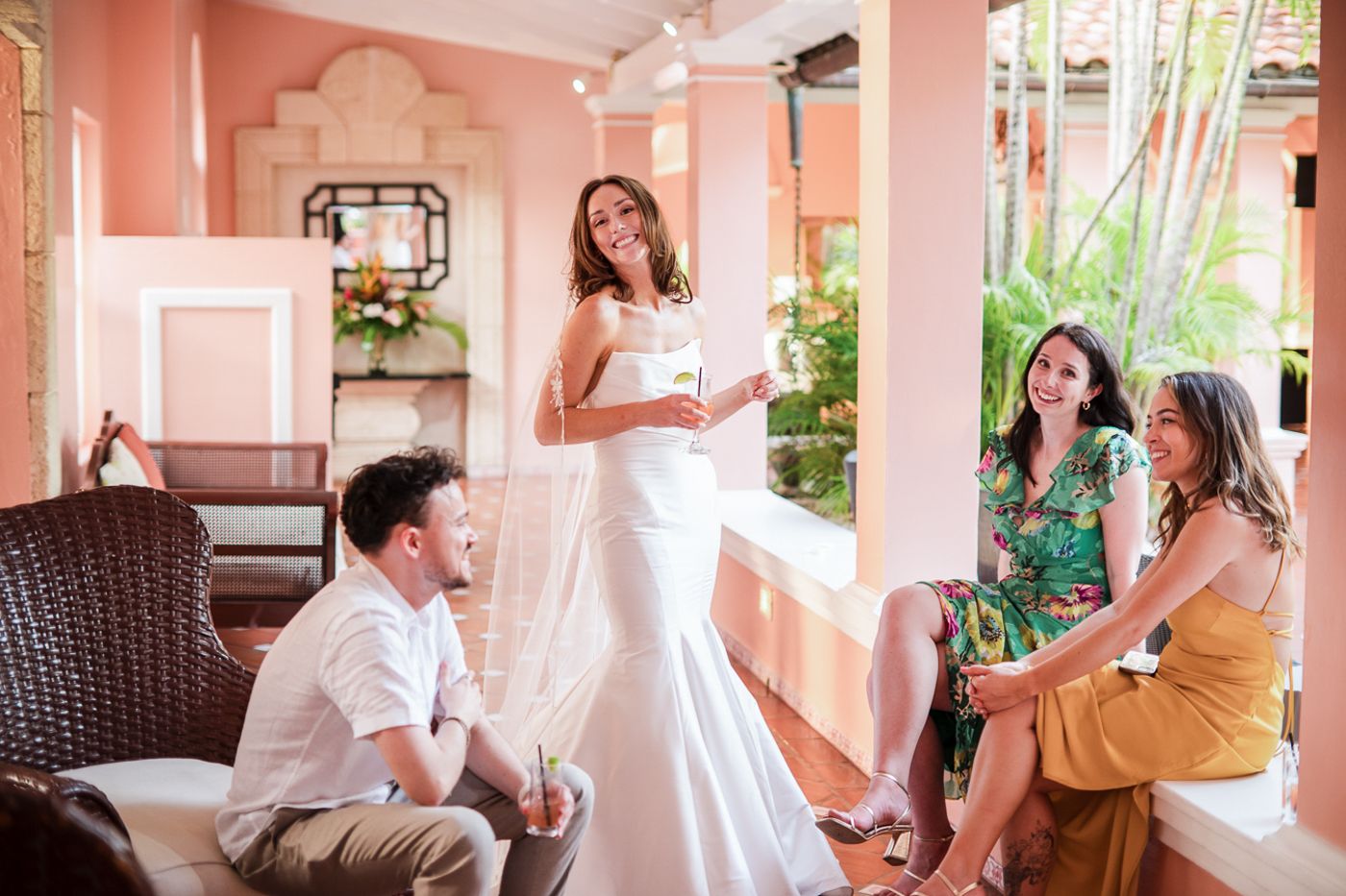 People socialize in an elegant pink-walled patio lounge area.