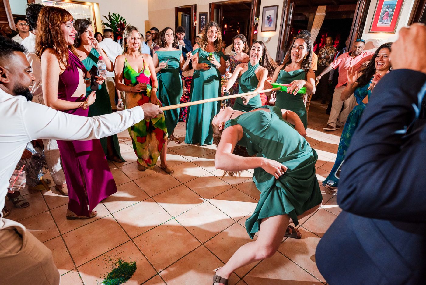 Lively reception dance floor filled with guests in green dresses and formal attire.